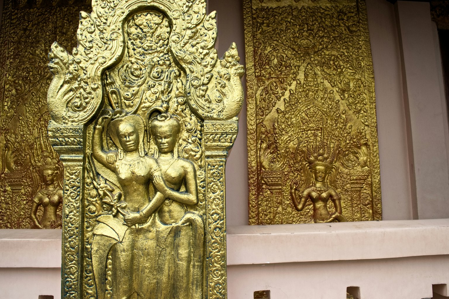Tượng khắc vàng của hai nhân vật với nền trang trí công phu