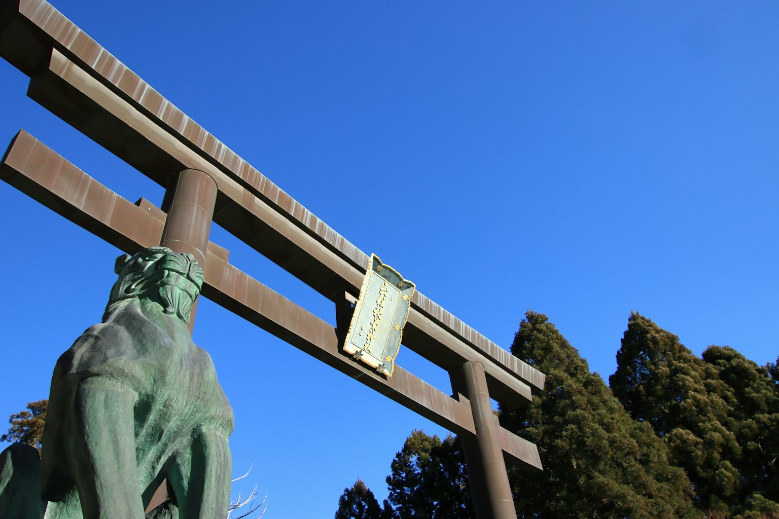 Cổng torii lớn và bức tượng ngựa dưới bầu trời xanh