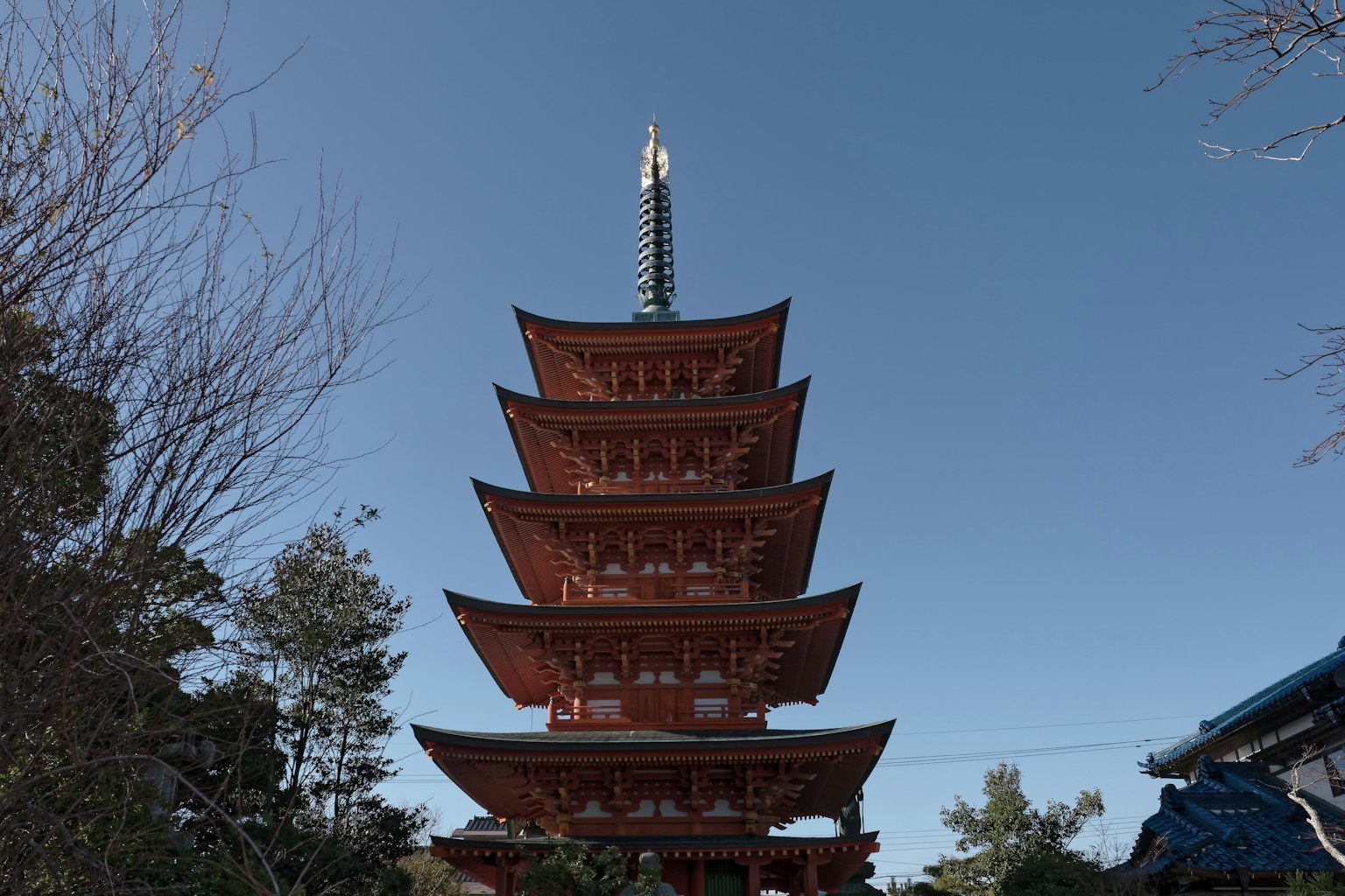 Pagoda roja de cinco pisos se erige bajo un cielo azul
