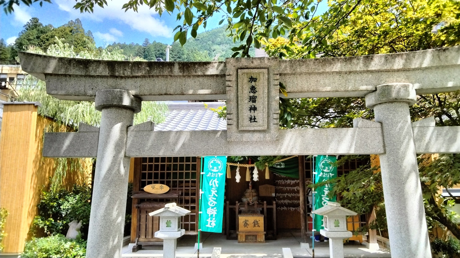 Hermosa vista de la puerta torii de un santuario con vegetación exuberante de fondo