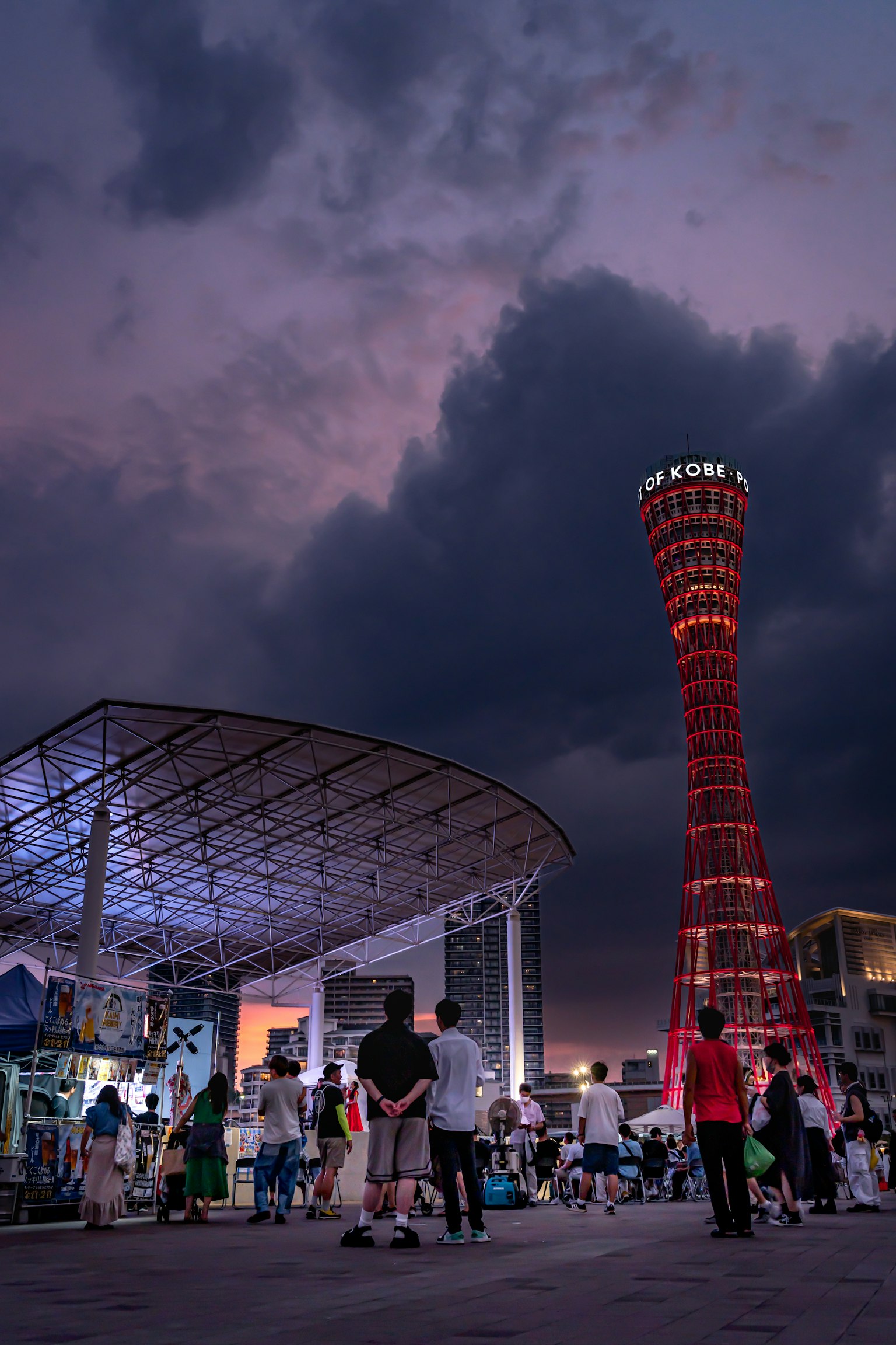 Torre del porto di Kobe illuminata di notte con persone riunite
