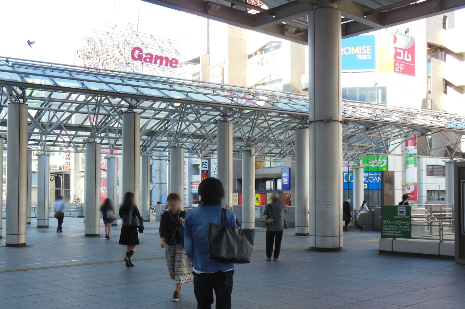 Pasillo comercial concurrido con letrero de Game visible