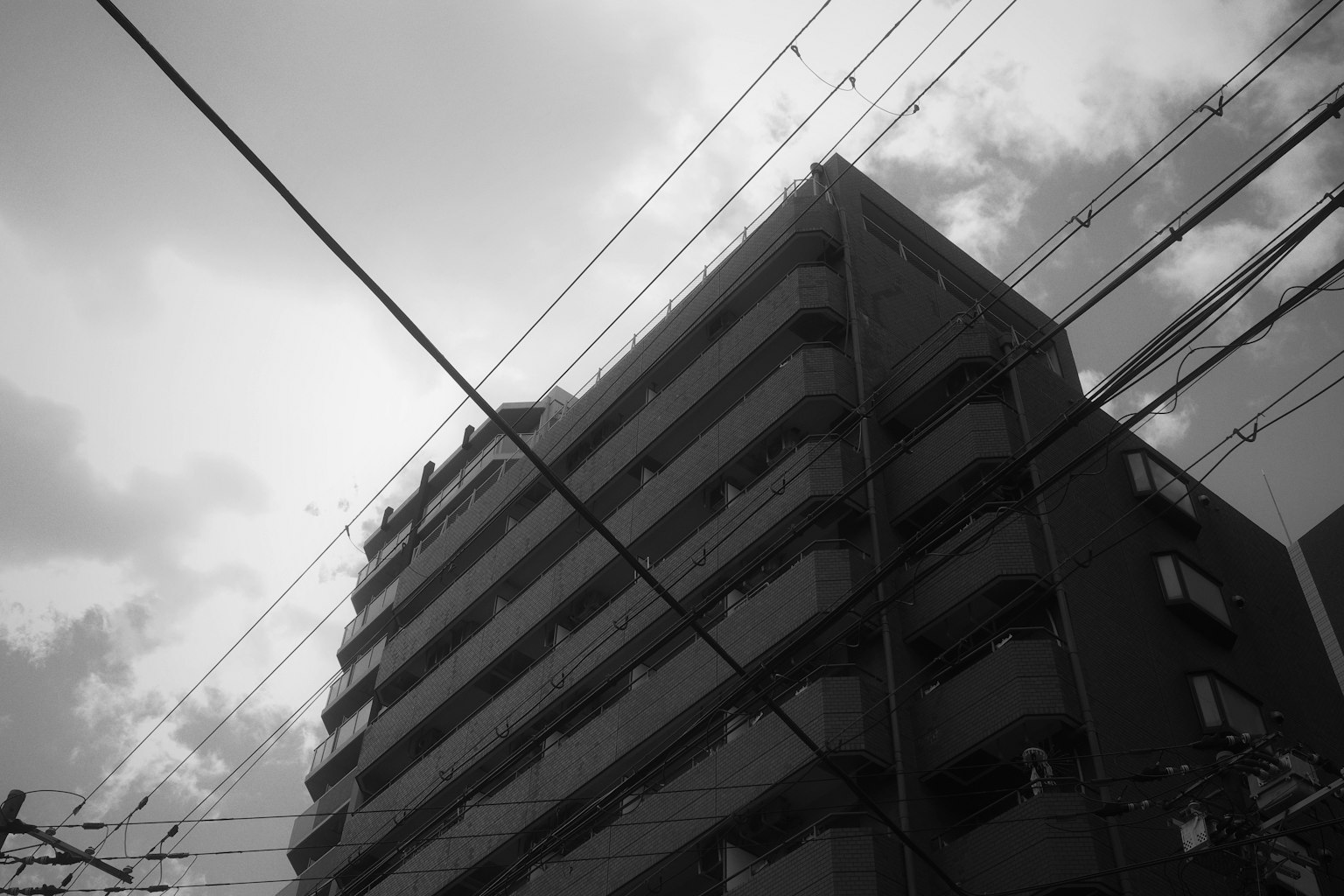 Monochrome view of a high-rise building intersected by power lines