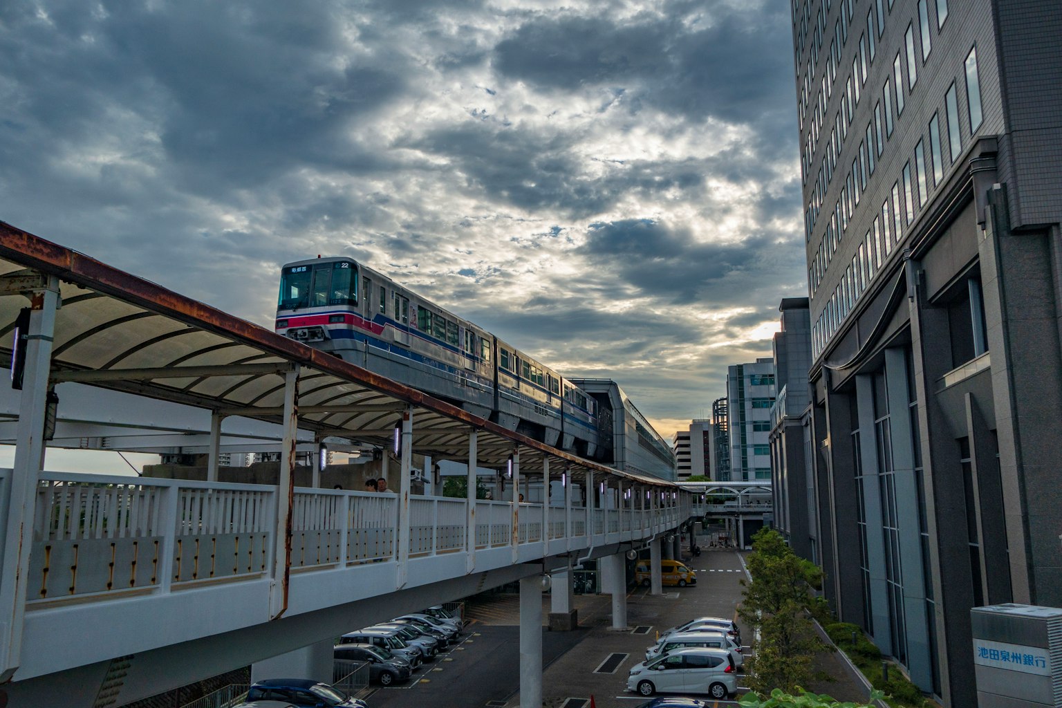 Urban landscape with elevated train and buildings under cloudy sky