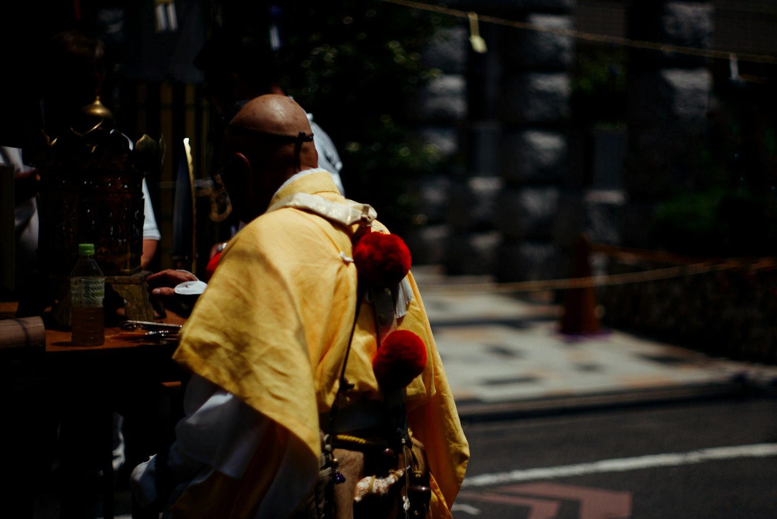 Un monaco in abito giallo seduto in un contesto di strada
