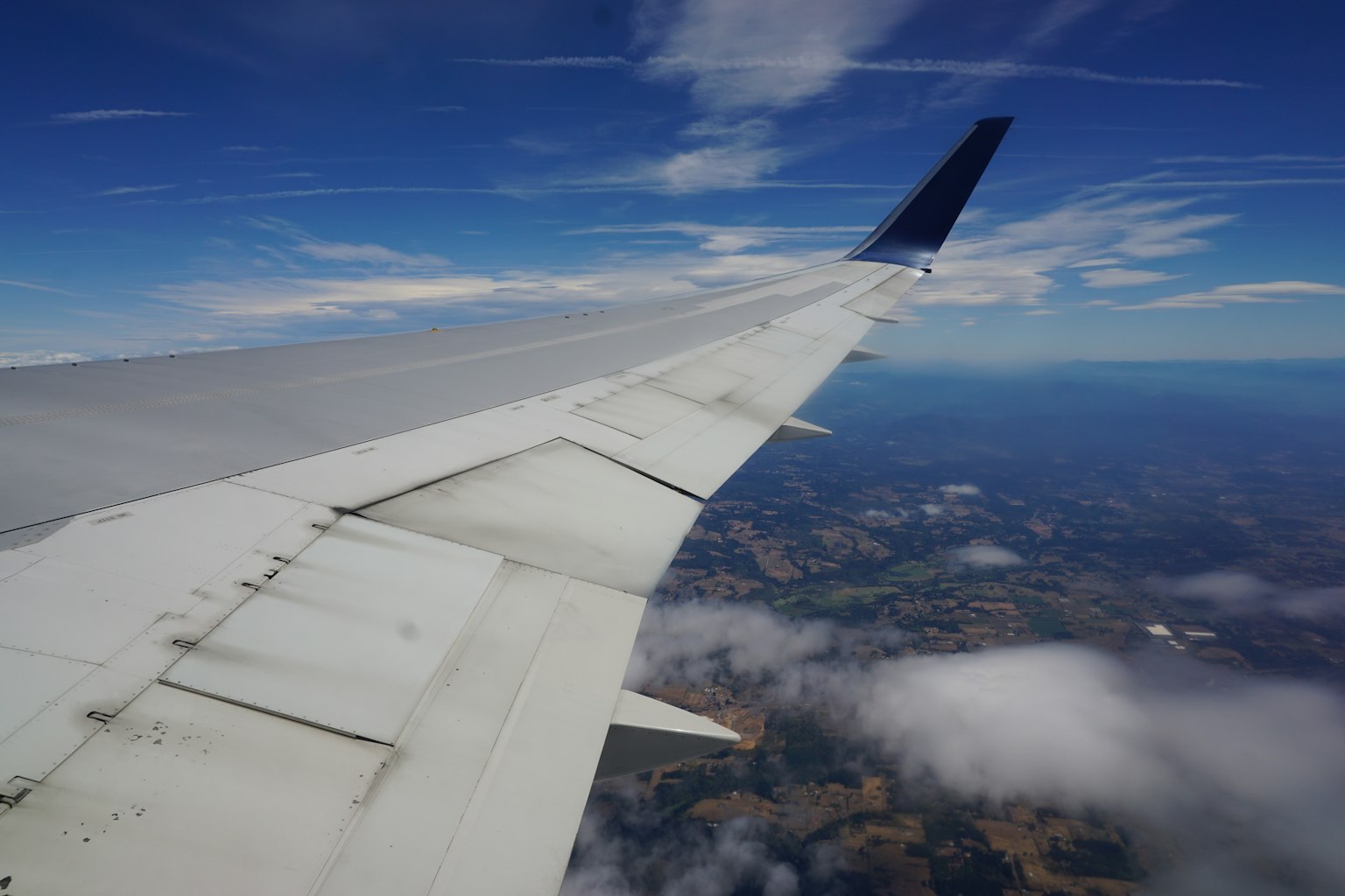 Ala di un aereo con vista del cielo blu e delle nuvole