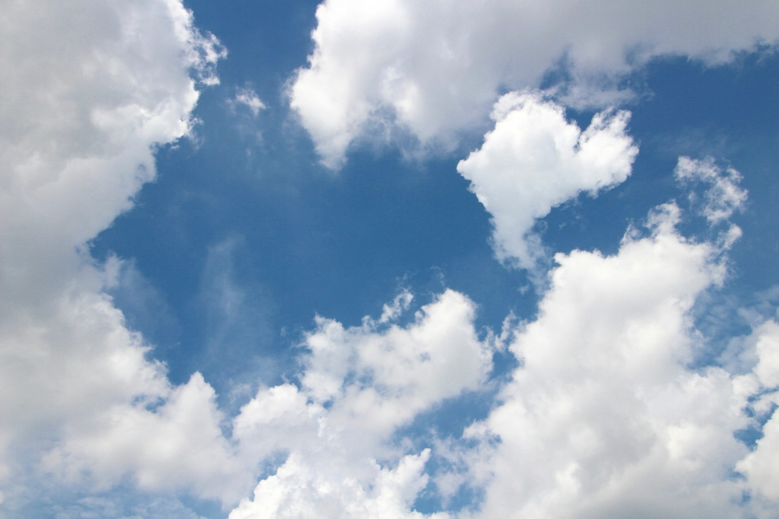 Un paesaggio con nuvole bianche dalle forme uniche contro un cielo blu