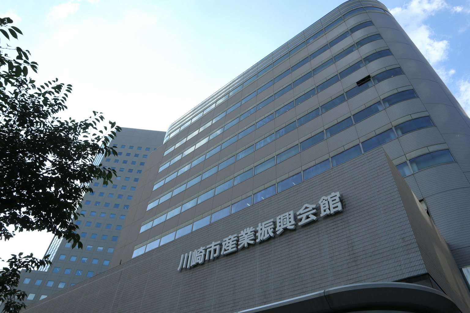 Primo piano del Palazzo di Promozione Industriale di Kawasaki con architettura moderna e cielo blu