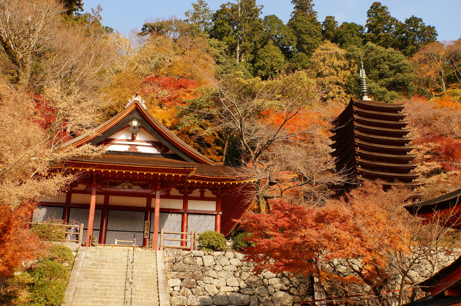 Templo japonés tradicional y pagoda rodeados de vibrante follaje otoñal