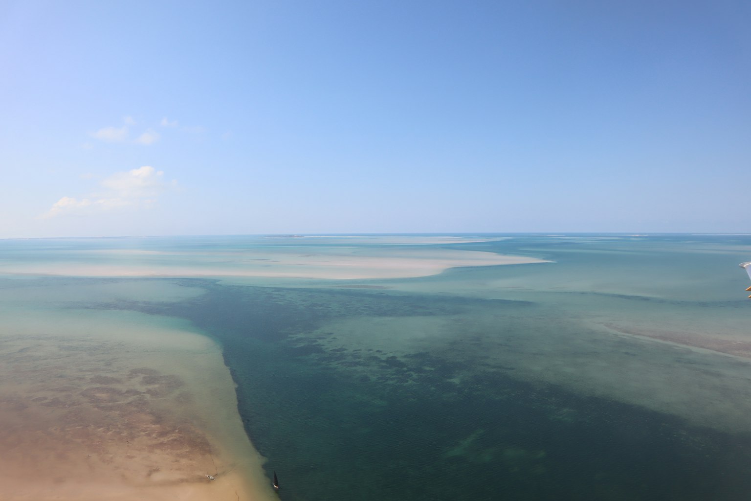 ทะเลสีน้ำเงินกว้างและท้องฟ้ากับชายหาดทรายและน้ำตื้น