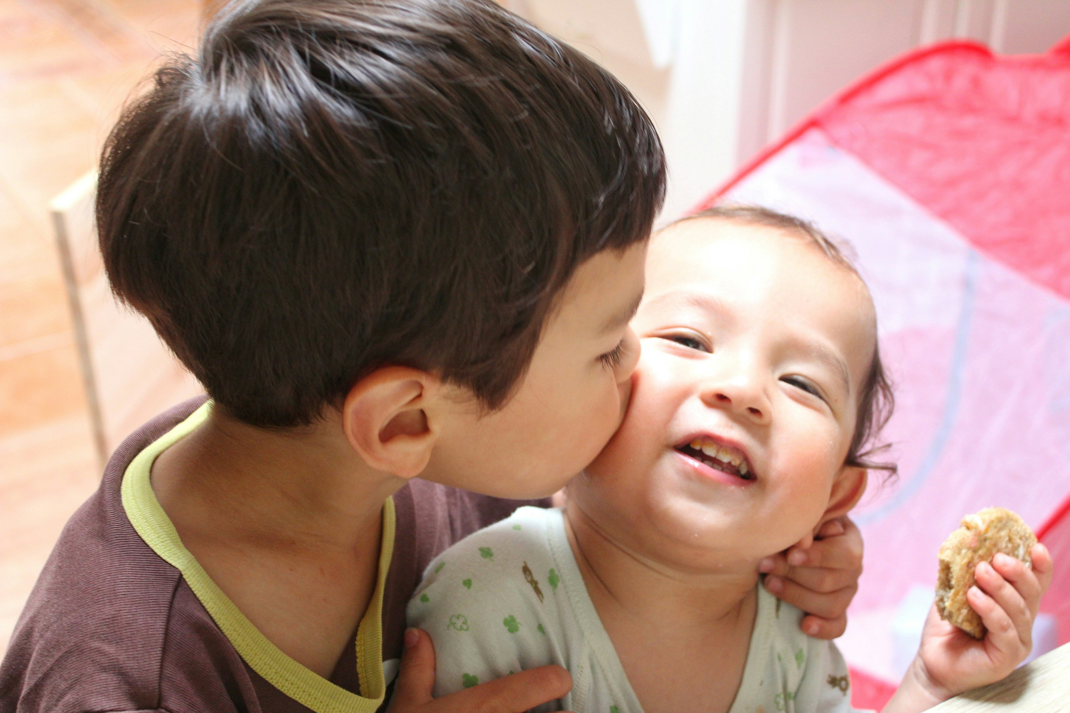 仲良しの兄弟が寄り添って頬にキスする瞬間