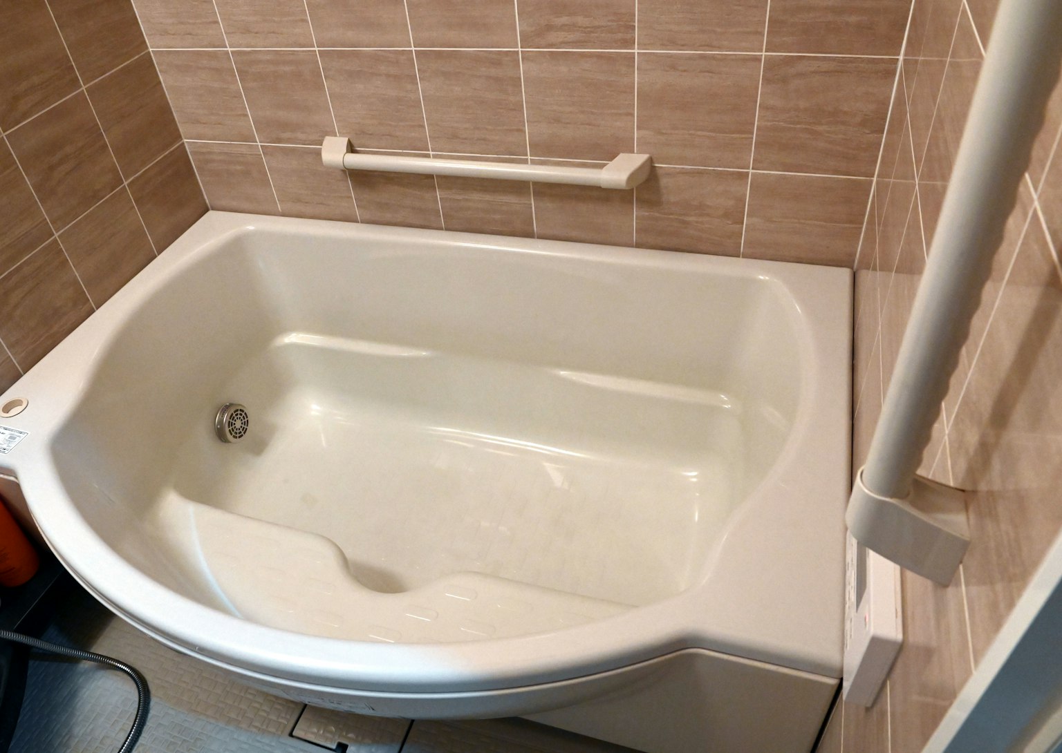 Eine weiße Badewanne in einem Badezimmer, umgeben von gefliesten Wänden
