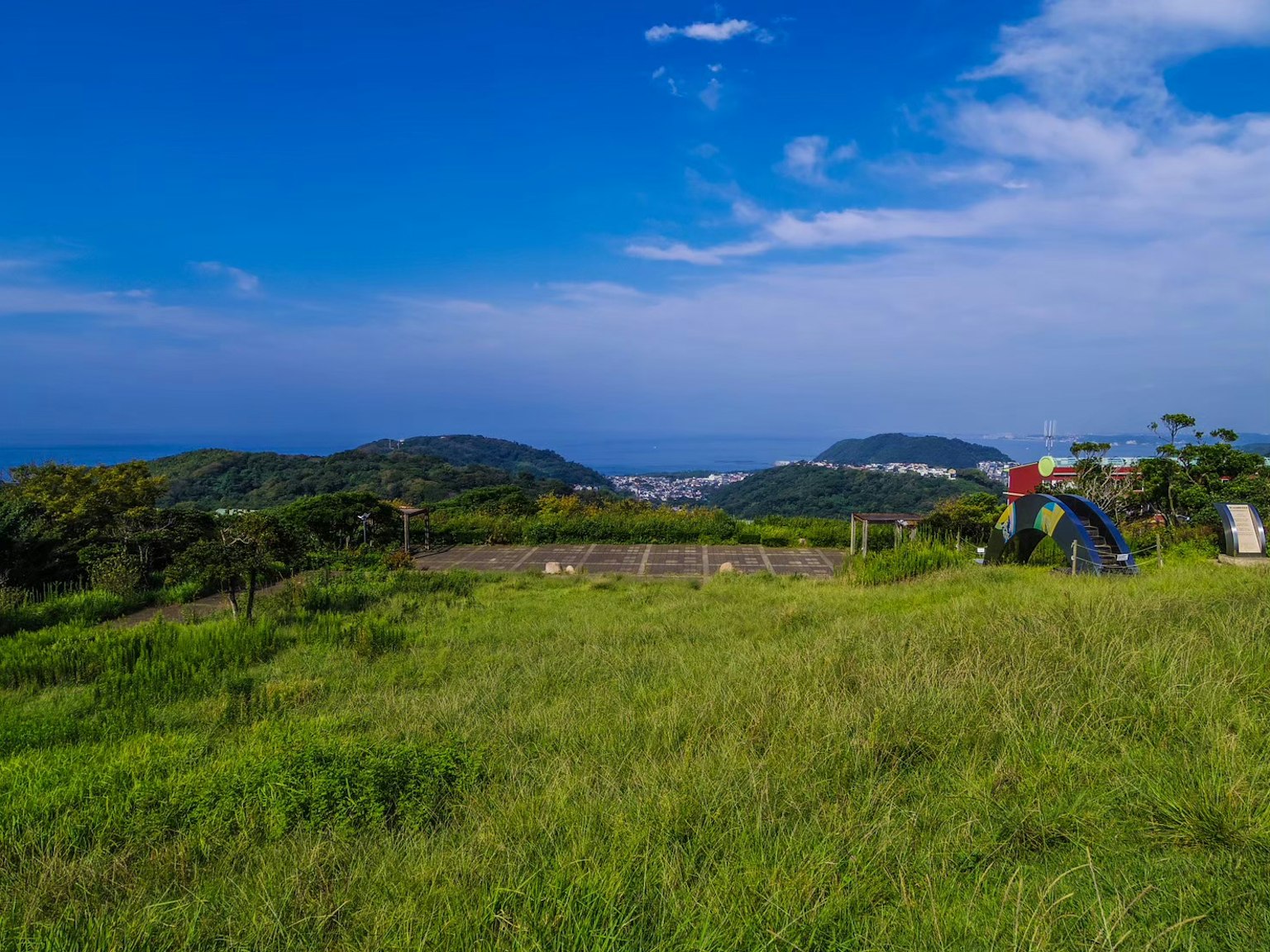 Scenic view with blue sky and green grass featuring a person