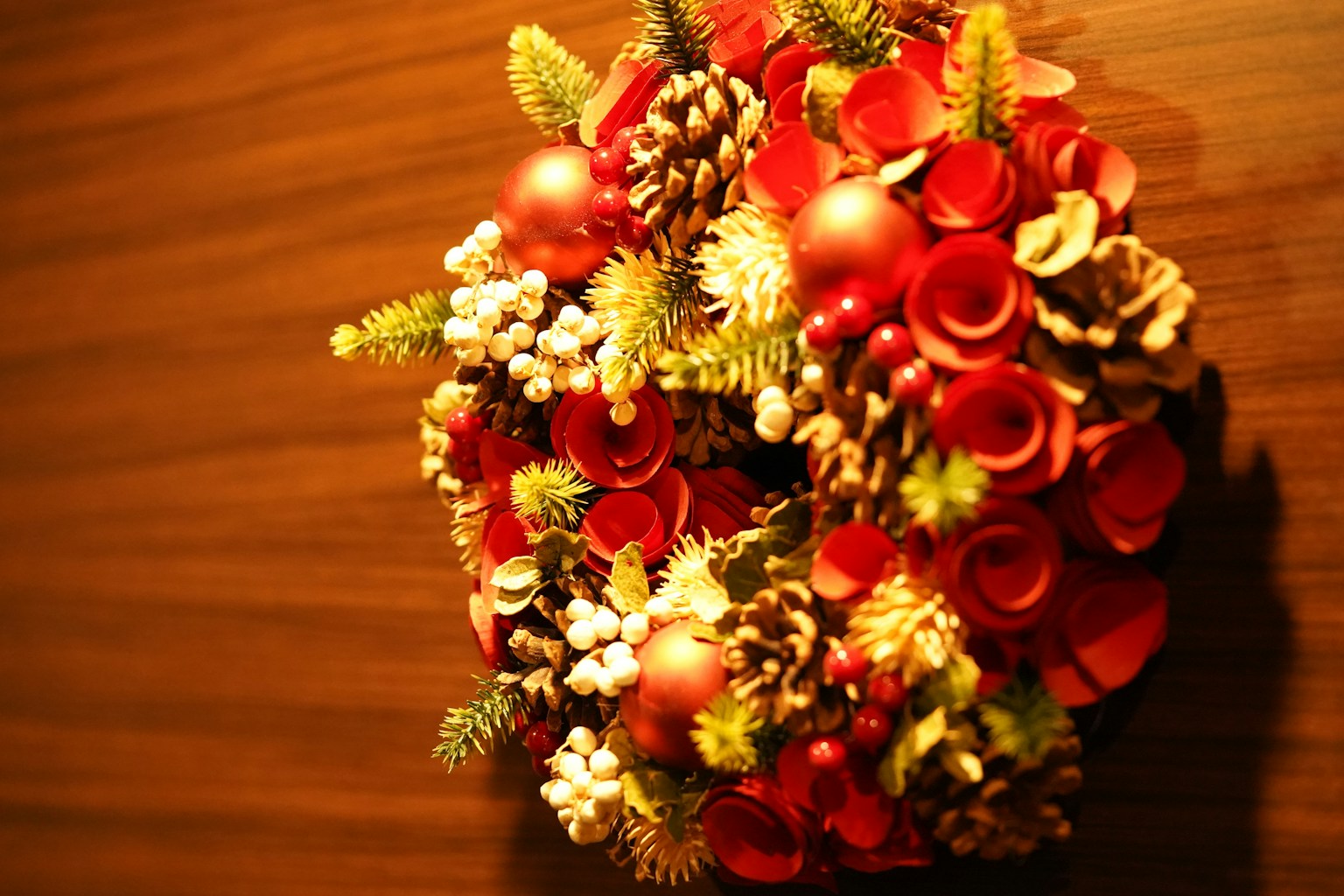 Weihnachtskranz aus roten Dekorationen und Tannenzapfen