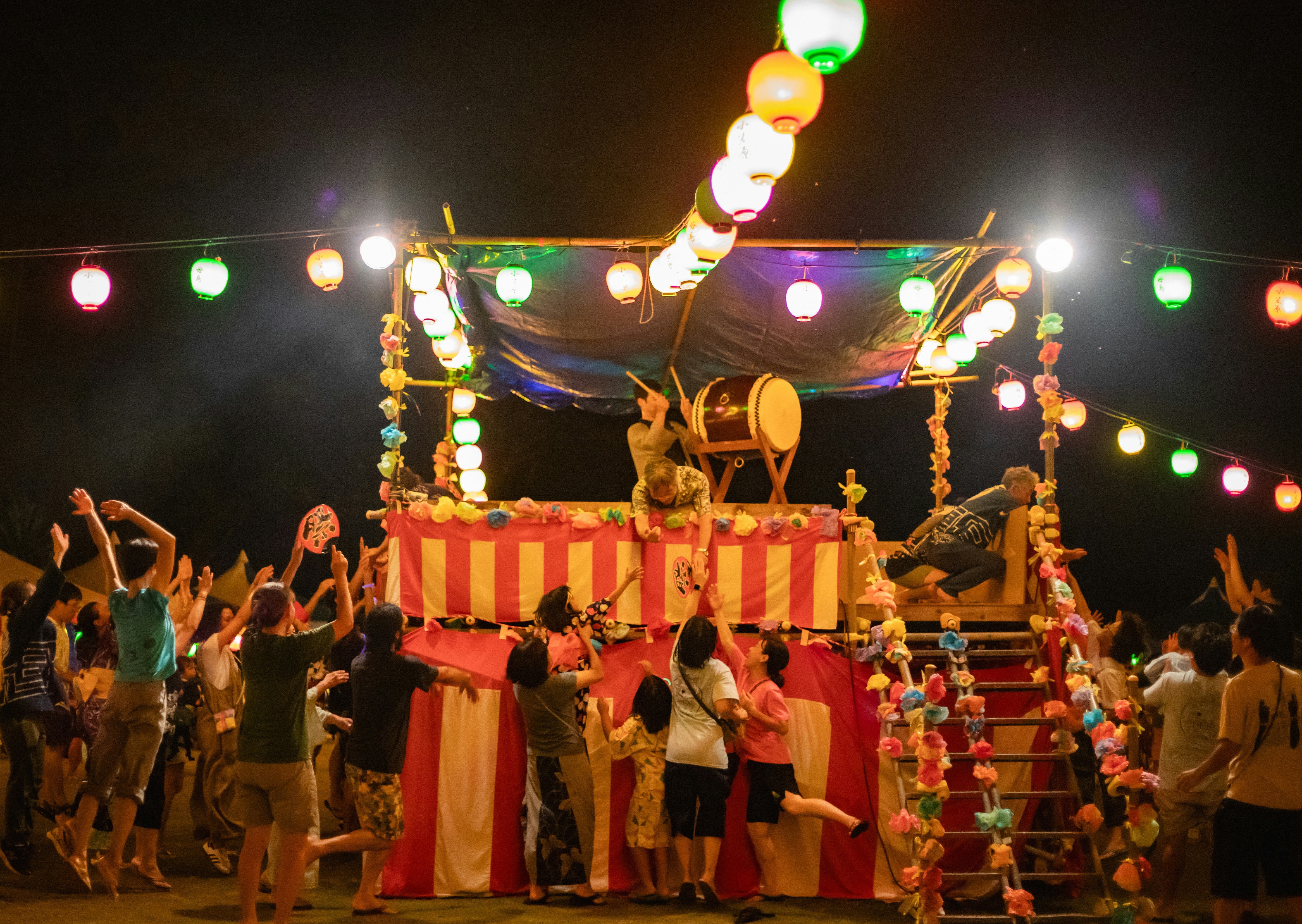 盆踊りの提灯と屋台のある夜の祭りの光景