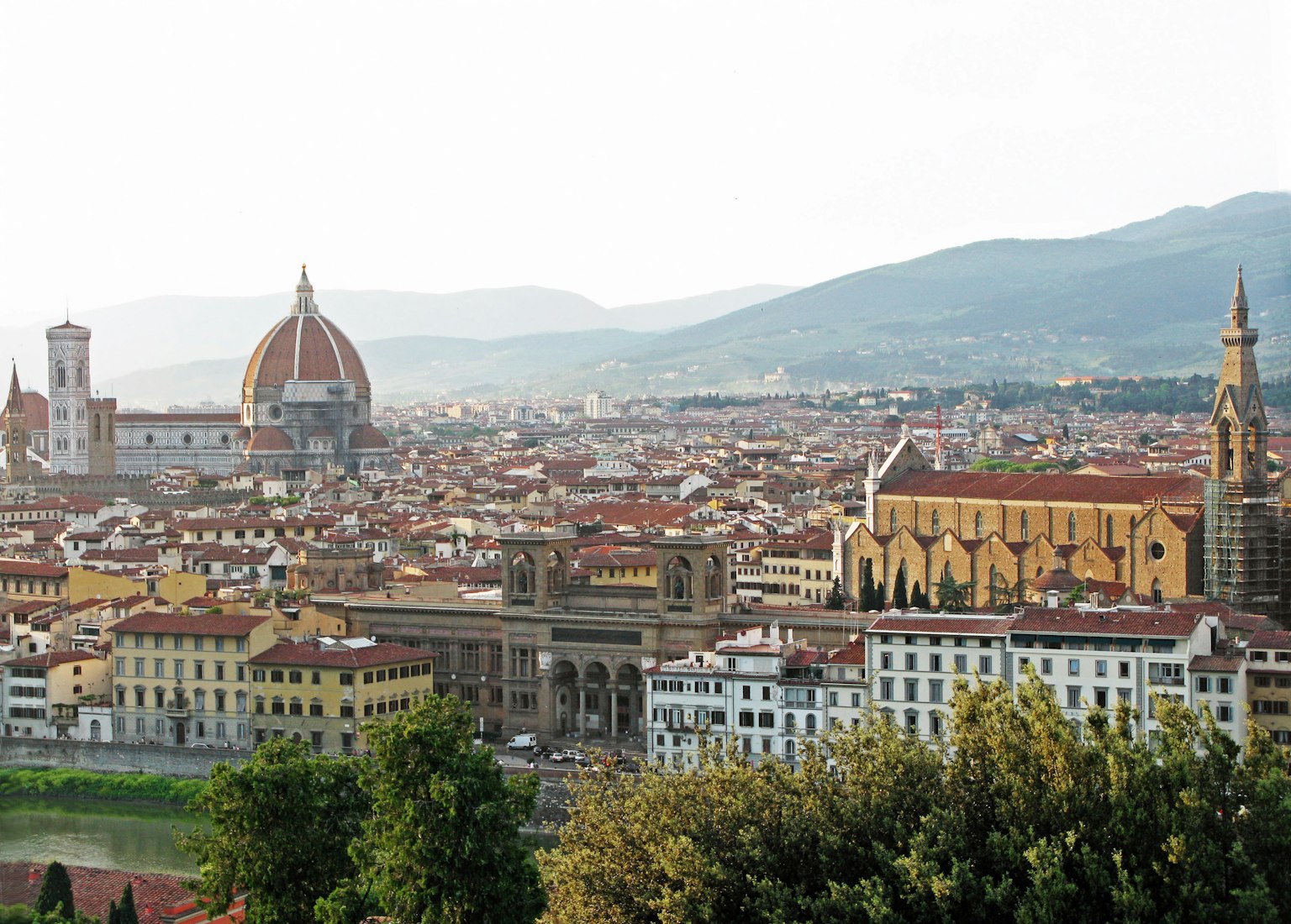 Vista panorámica de Florencia con el Duomo y edificios históricos desde una colina verde