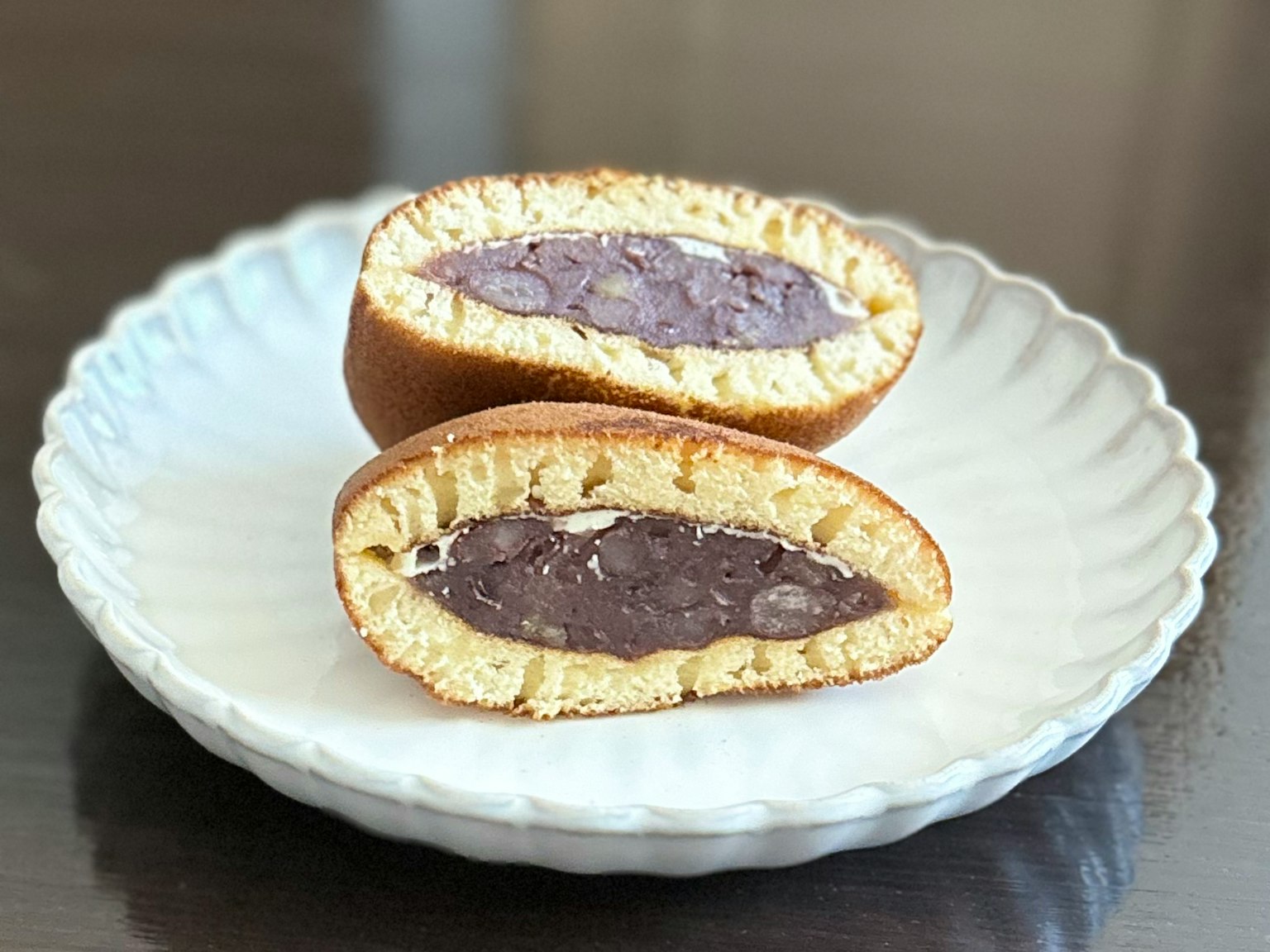 Immagine di un dolce tagliato a metà su un piatto bianco che rivela un ripieno viola
