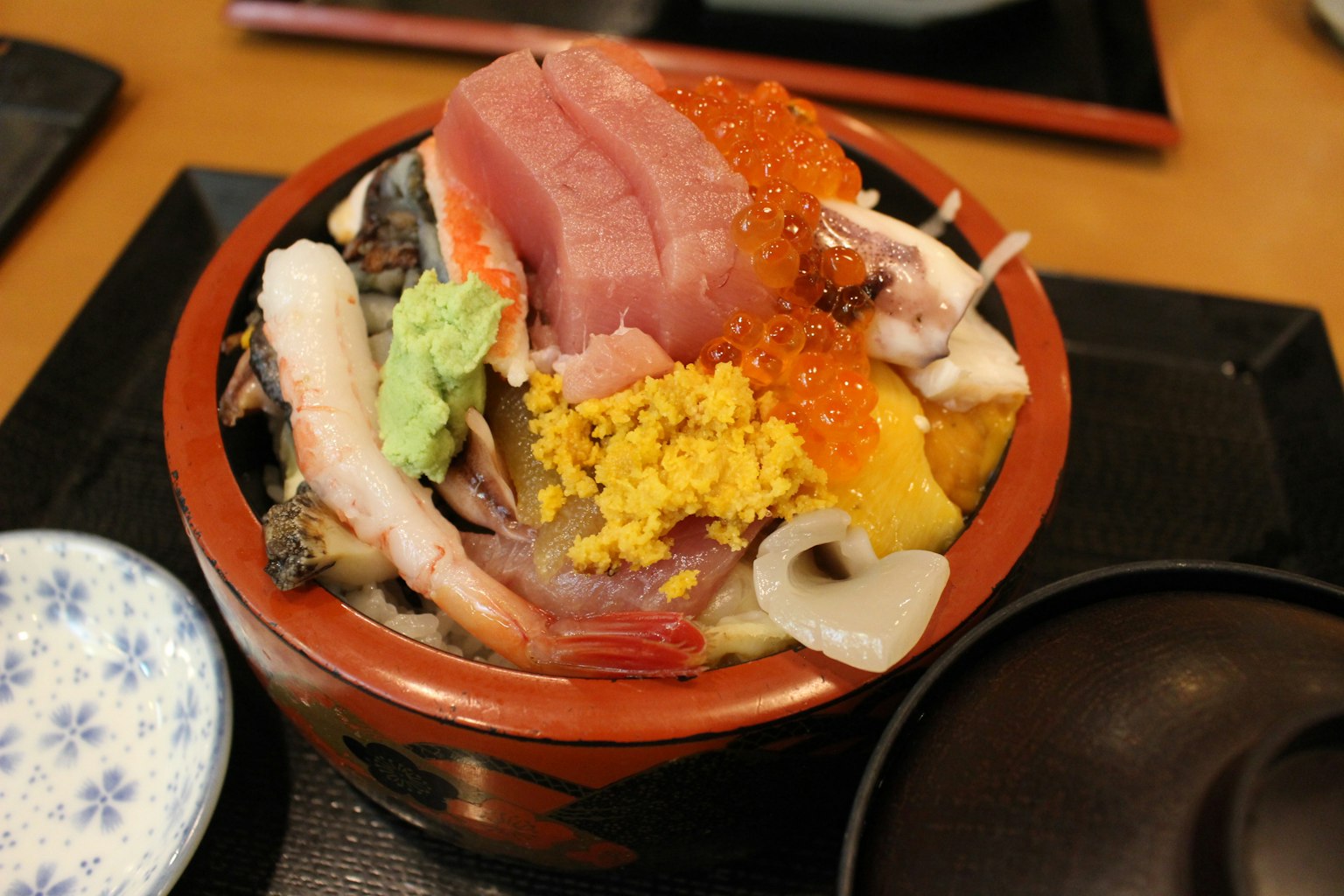 Eine Schüssel mit Meeresfrüchten, belegt mit frischem Sashimi und Rogen