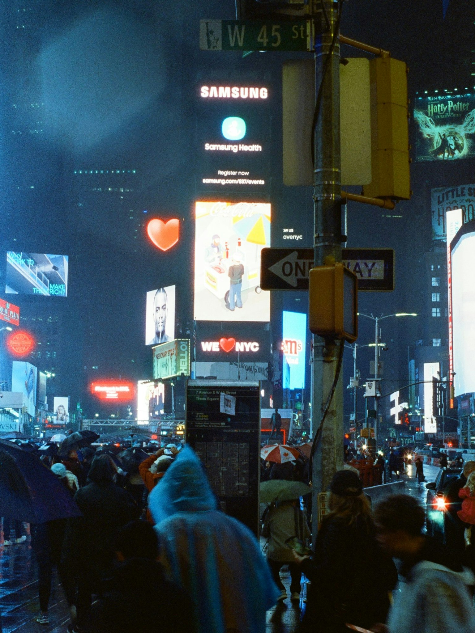 Times Square affollato di notte con pubblicità vivaci
