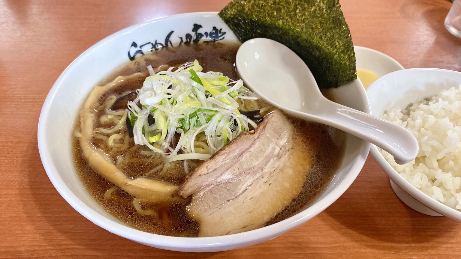 碗中拉麵上放有切好的蔥和豬肉