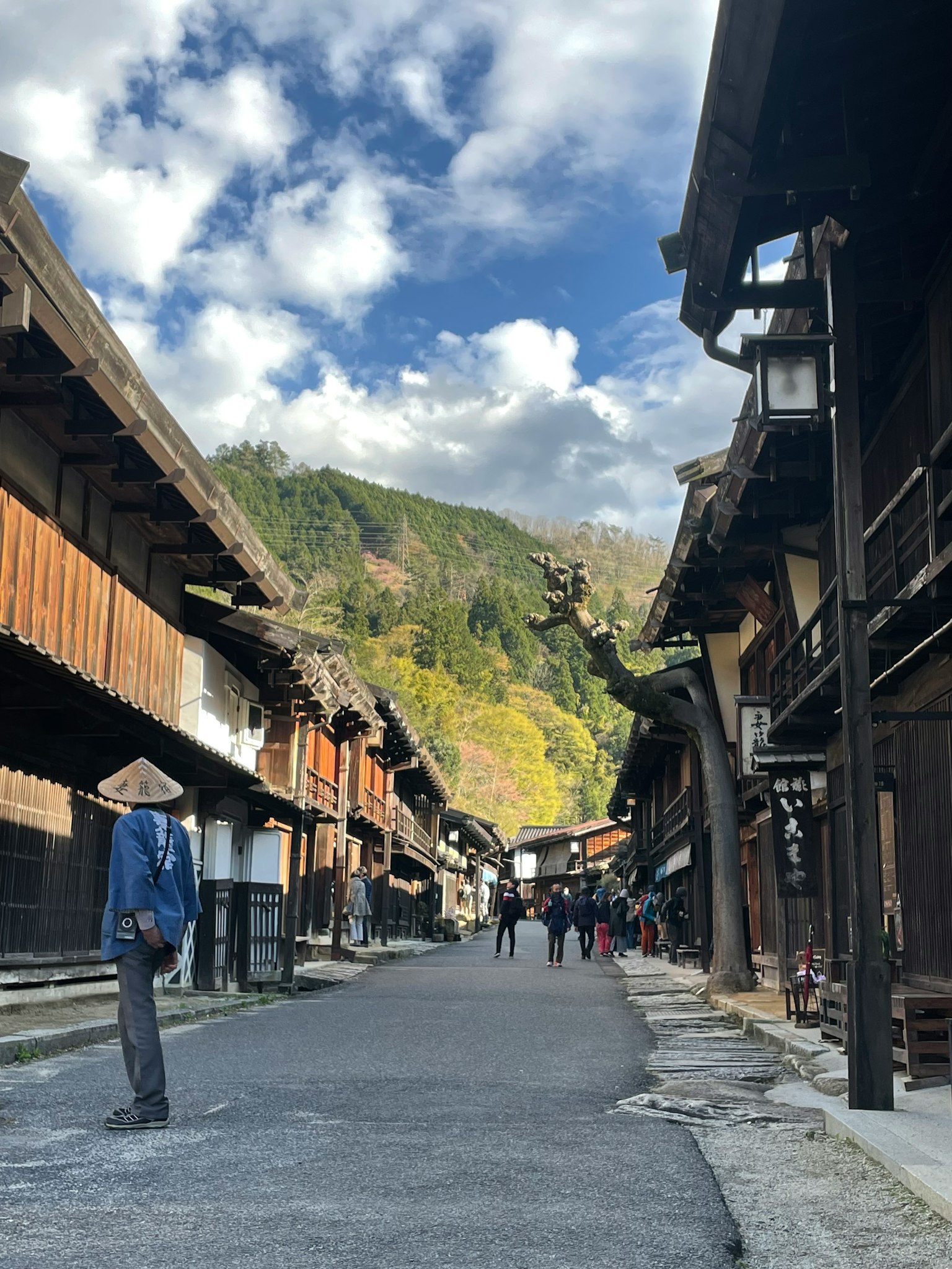 Rue historique avec des bâtiments en bois traditionnels et un arrière-plan de montagne