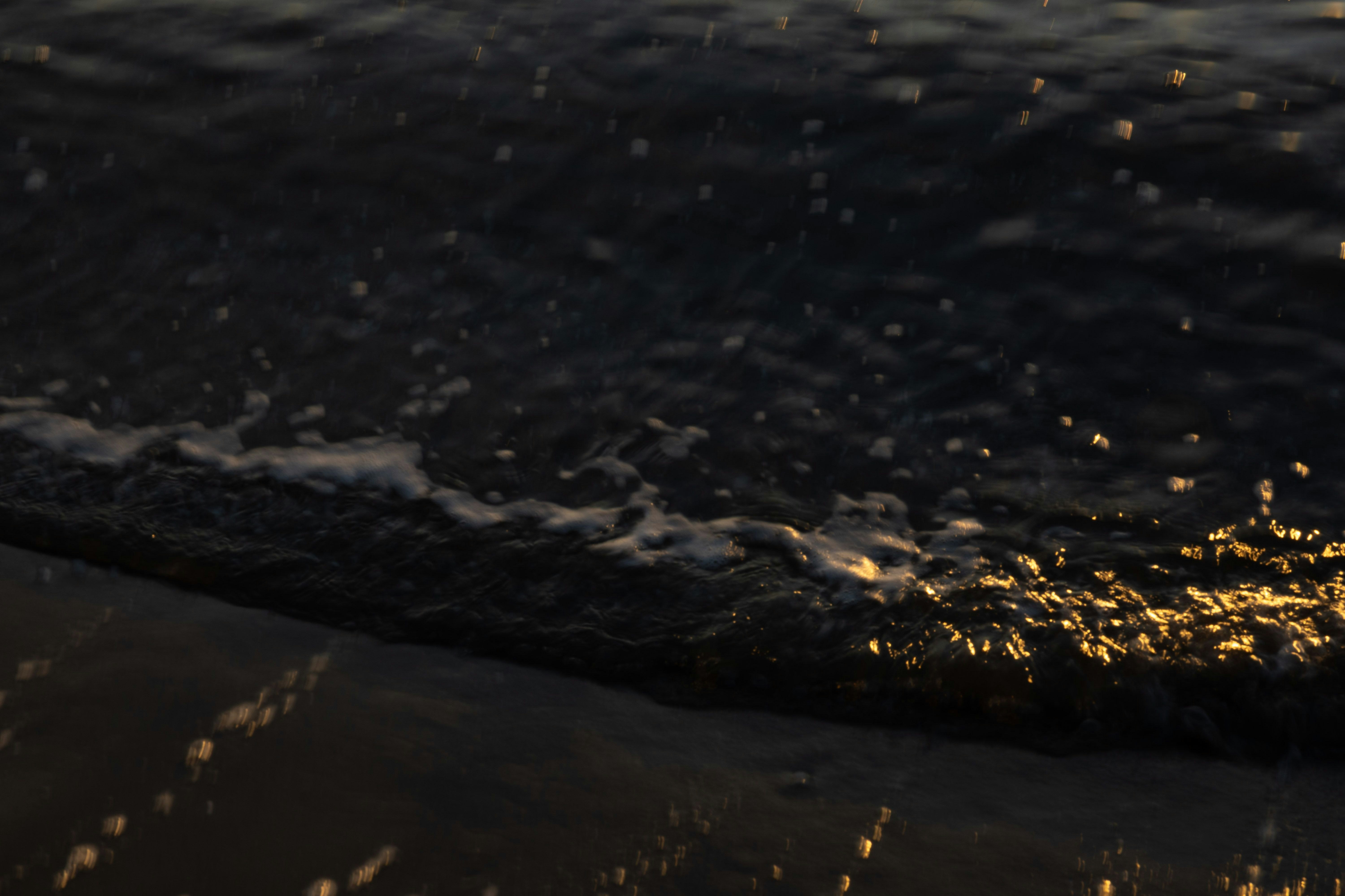 波打ち際の水面に広がる夕暮れの光