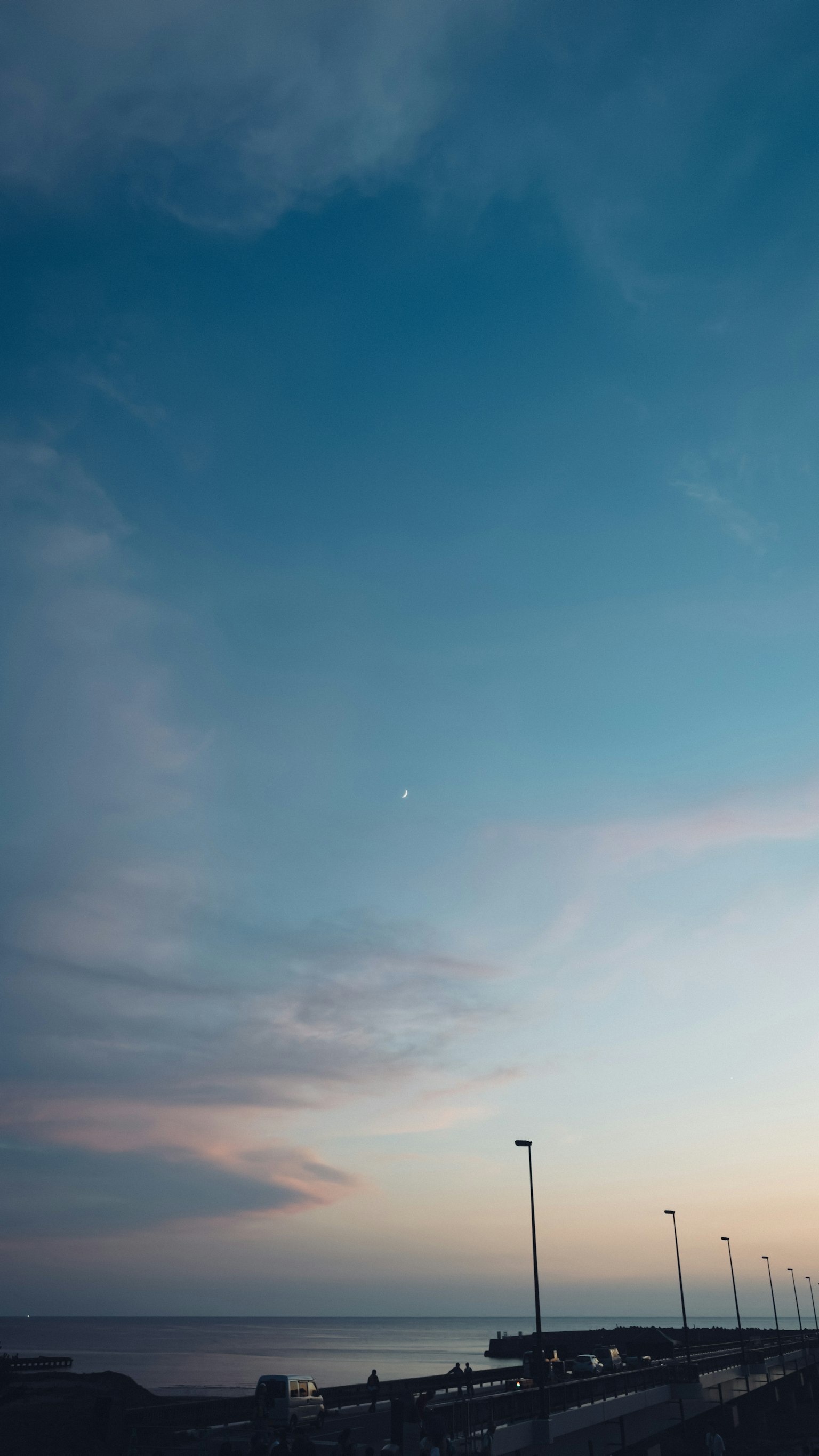 Scena crepuscolare con cielo blu e nuvole morbide sopra l'oceano