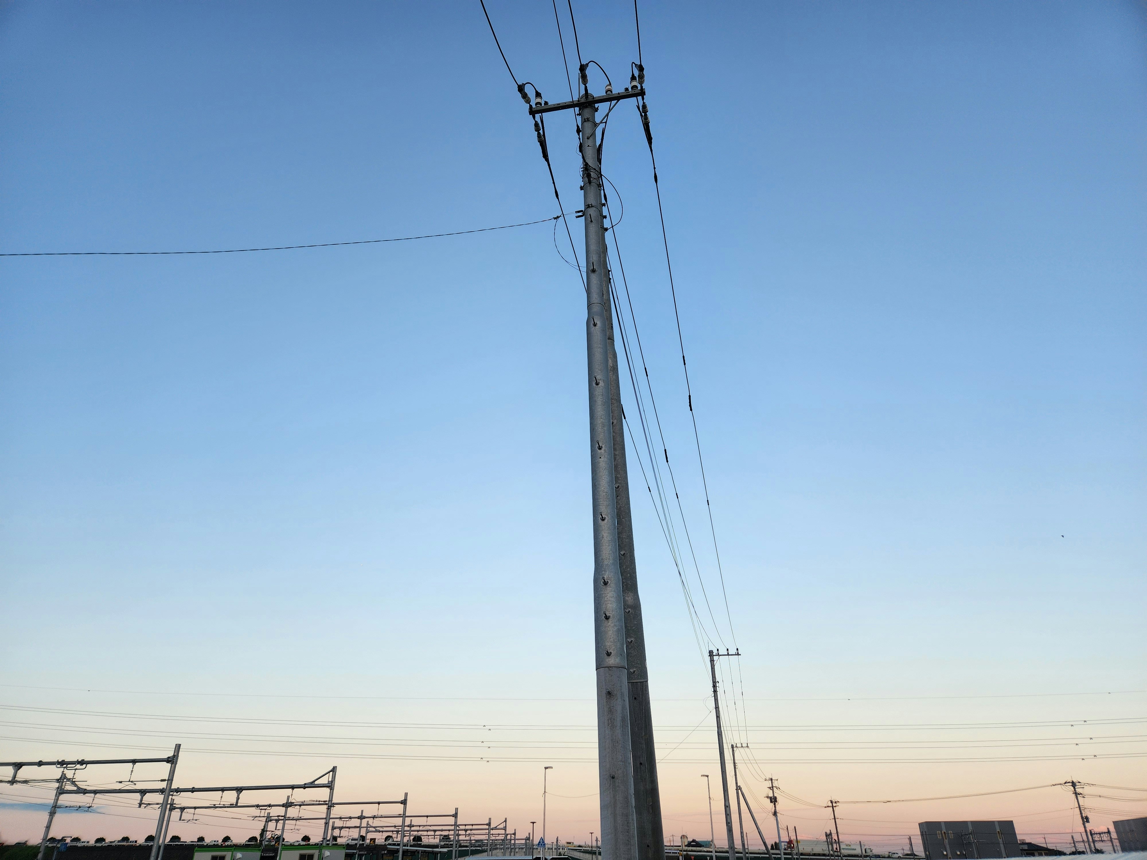 electric poles and overhead wires against a twilight sky