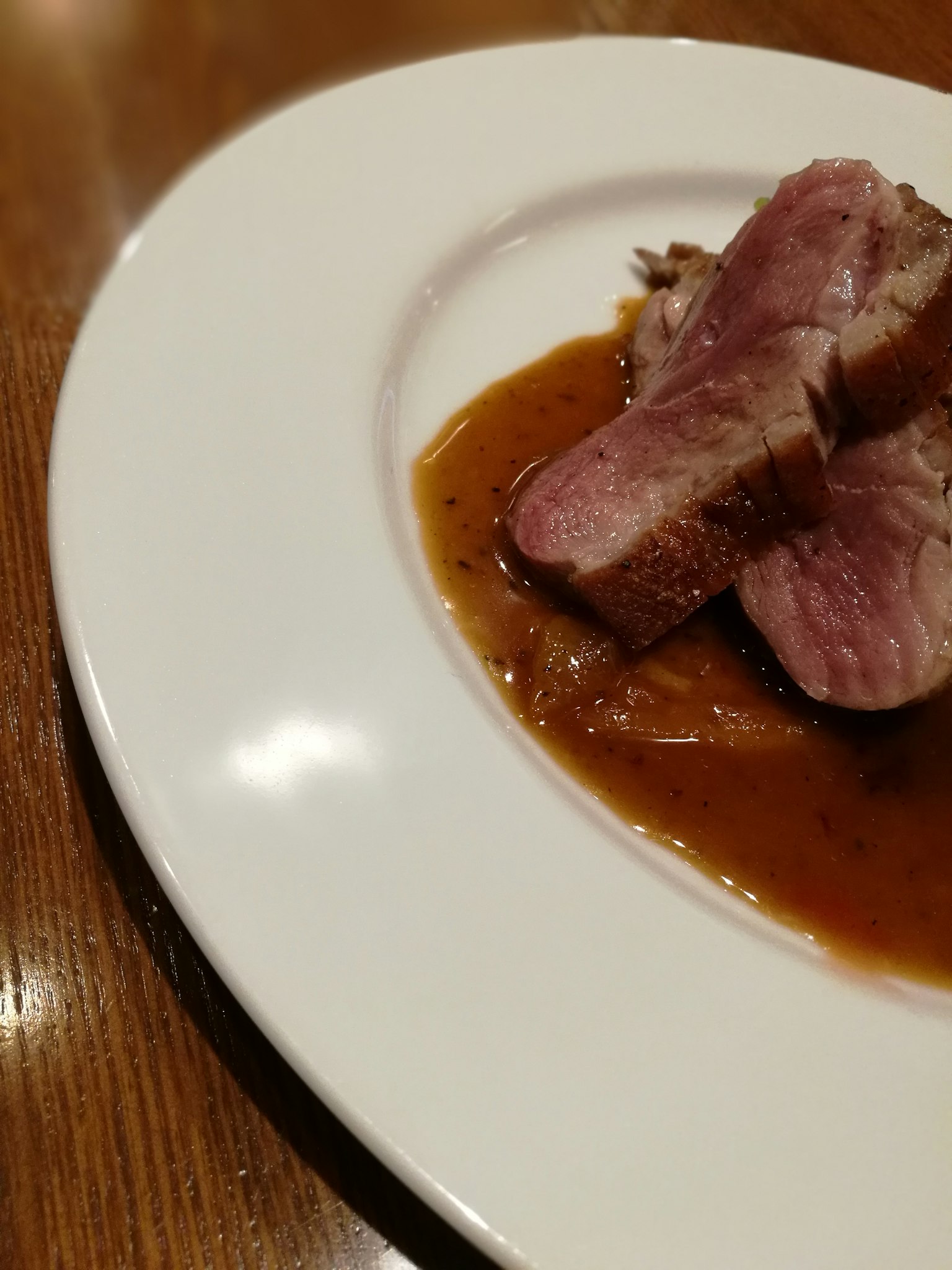 Elegante Präsentation eines Fleischgerichts mit Sauce auf einem weißen Teller