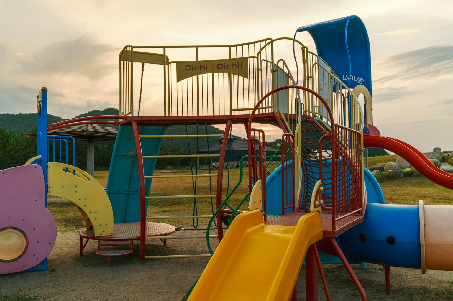 Estructura de parque colorida con tobogán y área de escalada