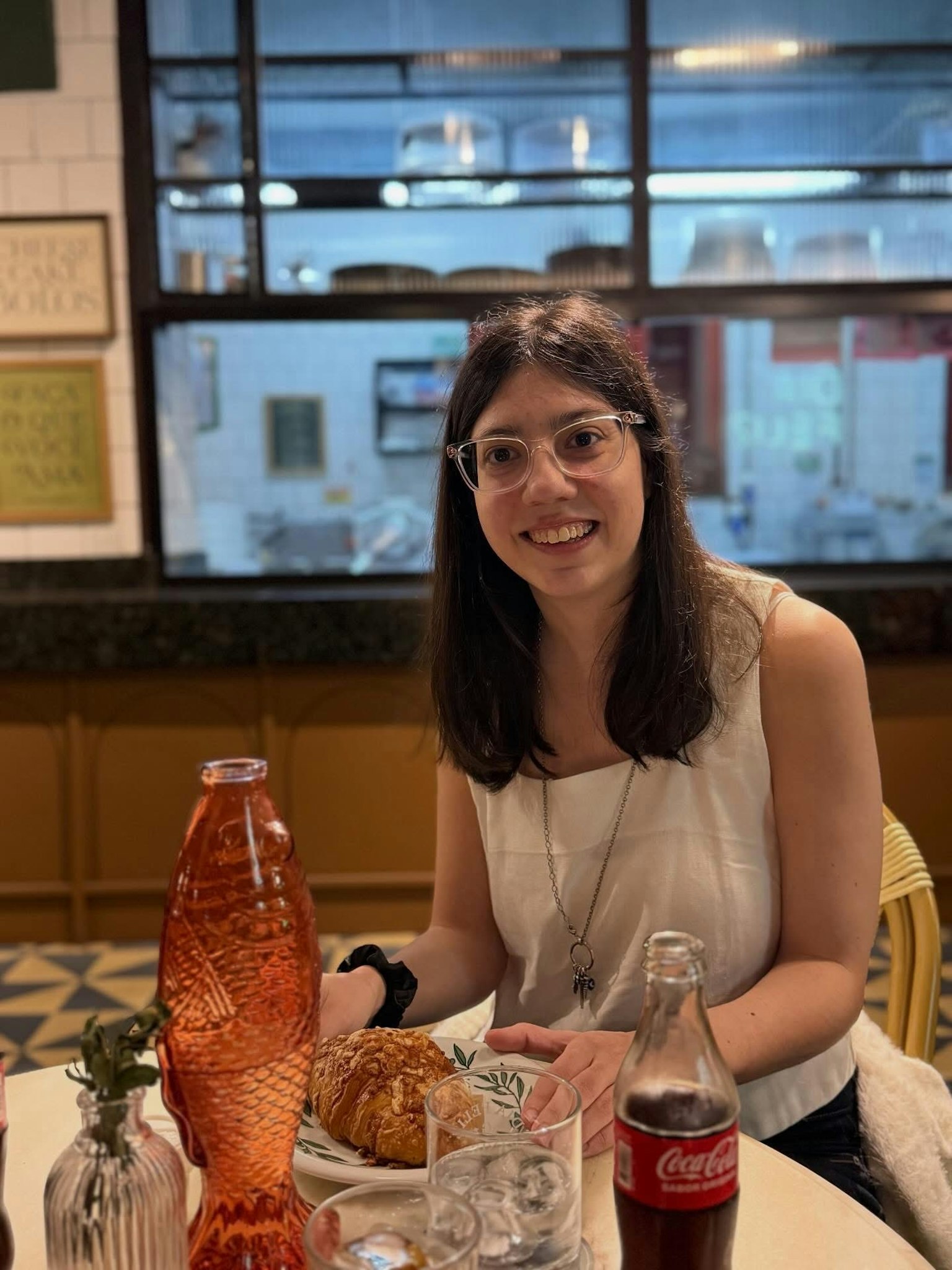 カジュアルなレストランで食事を楽しむ女性 笑顔でテーブルに座っている 食べ物と飲み物が並んでいる