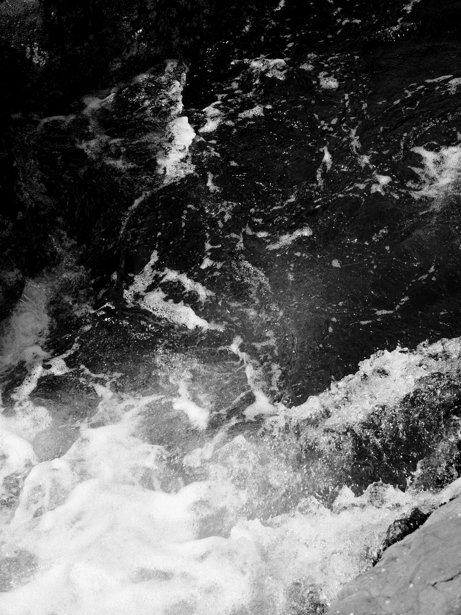 黒と白の水の流れの写真 波と泡が混ざり合う様子