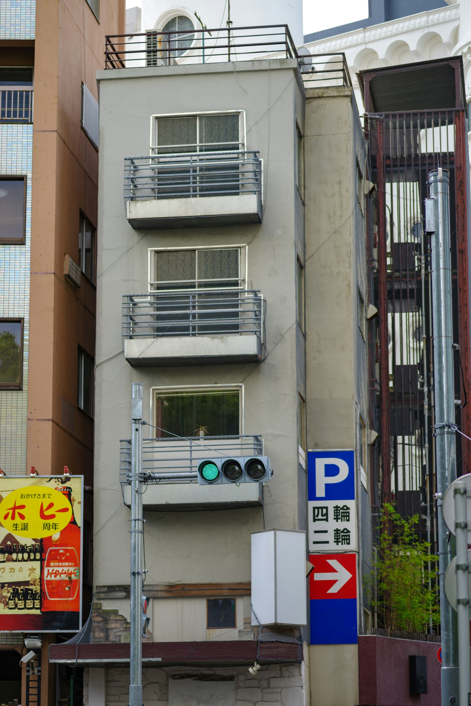 Fachada de un edificio estrecho con balcones en un entorno urbano