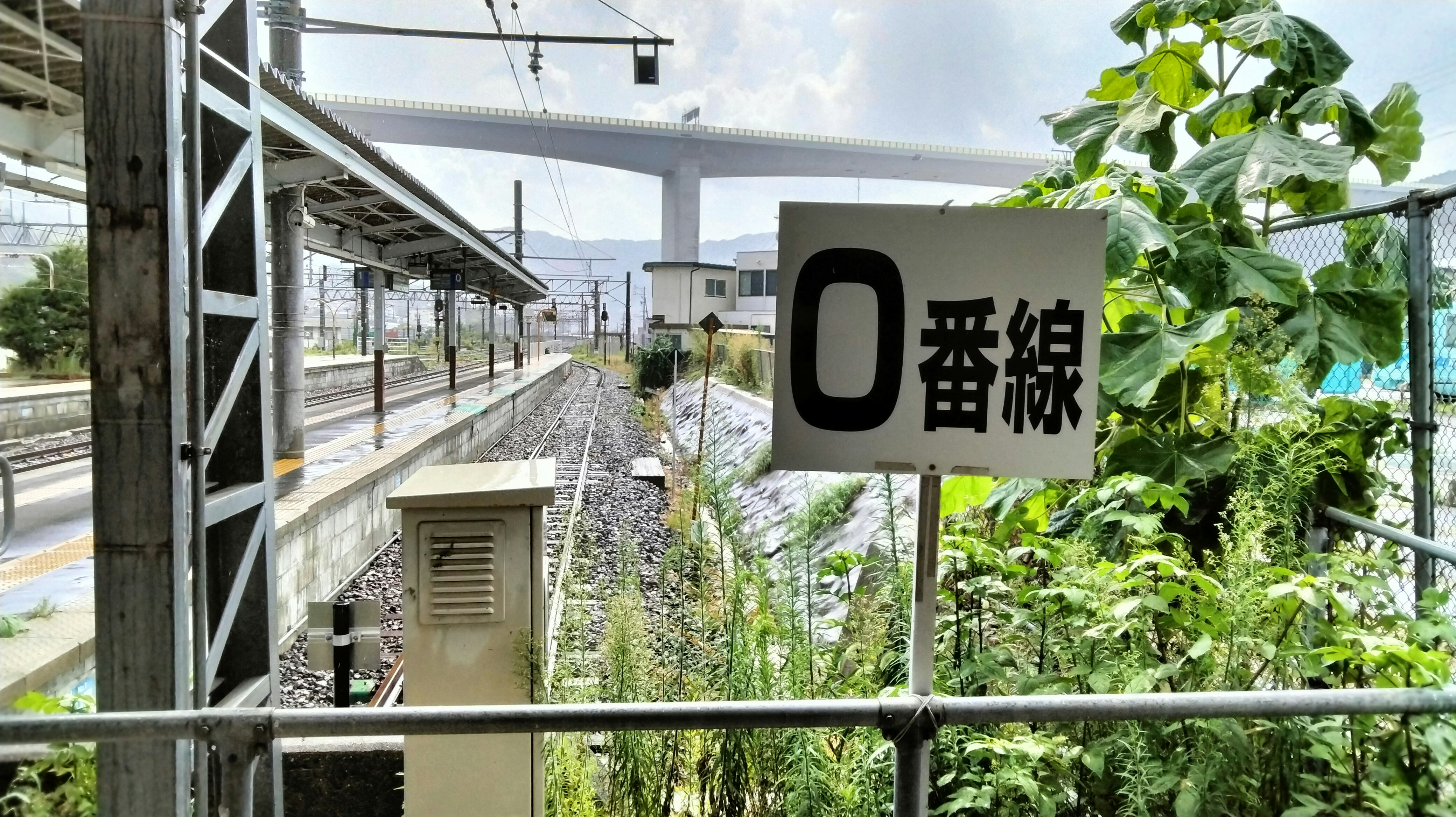 線路沿いの高架と「0番線」表示のある駅構内