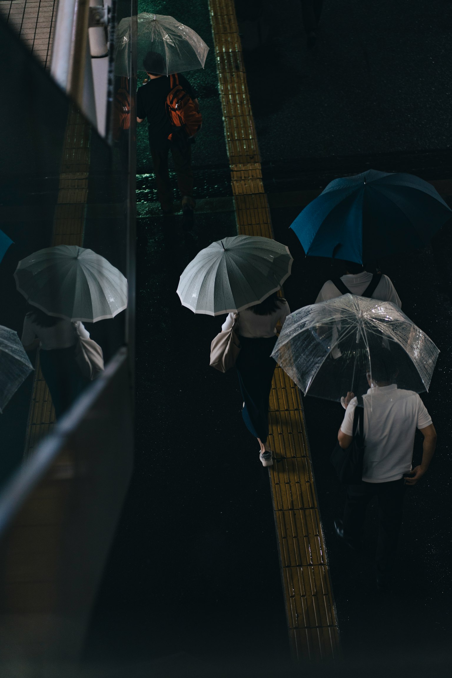 人们在雨中撑着伞走路