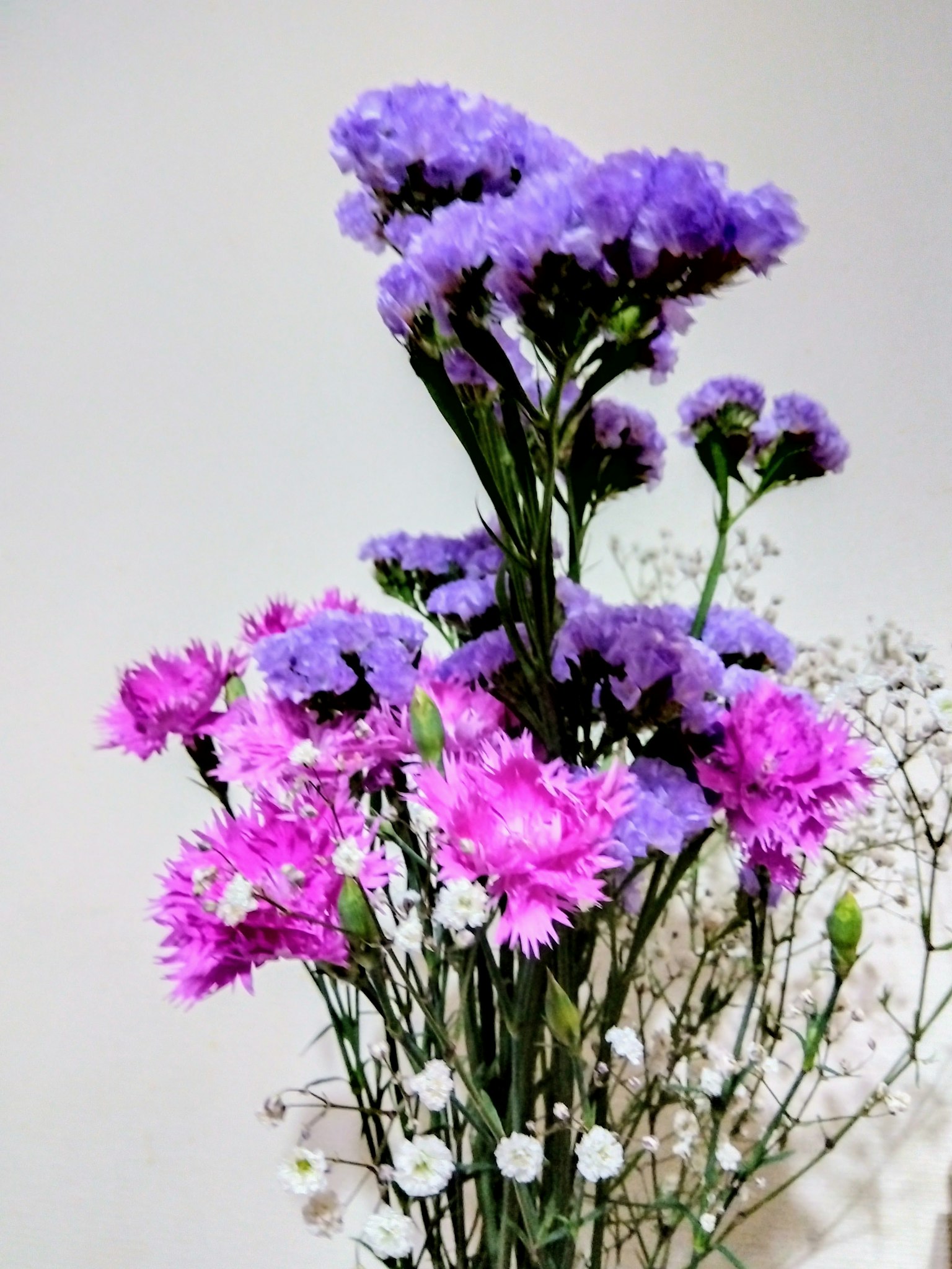 Hermoso arreglo de flores moradas y rosas con flores blancas