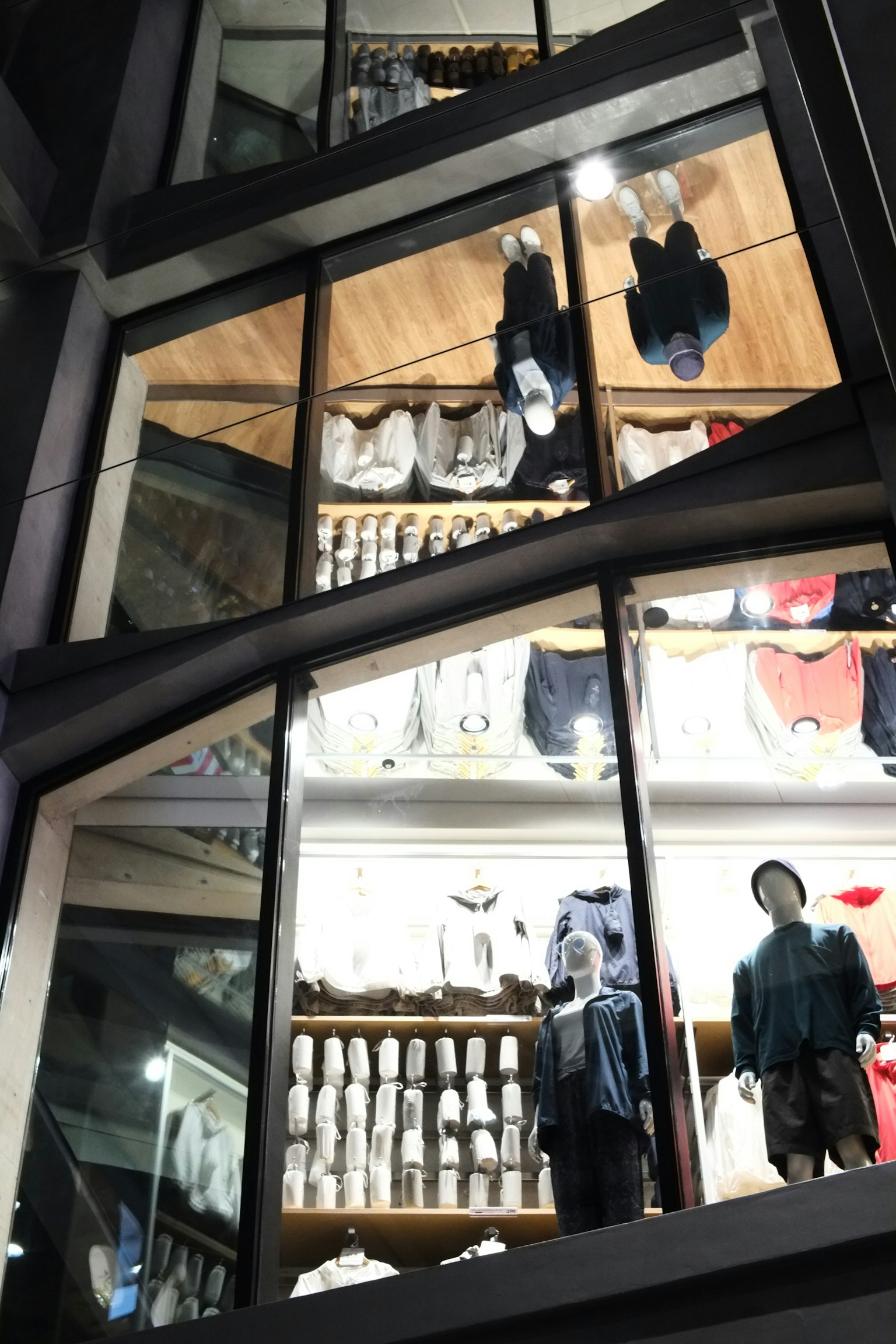 Vitrina de tienda moderna que refleja ropa y maniquíes