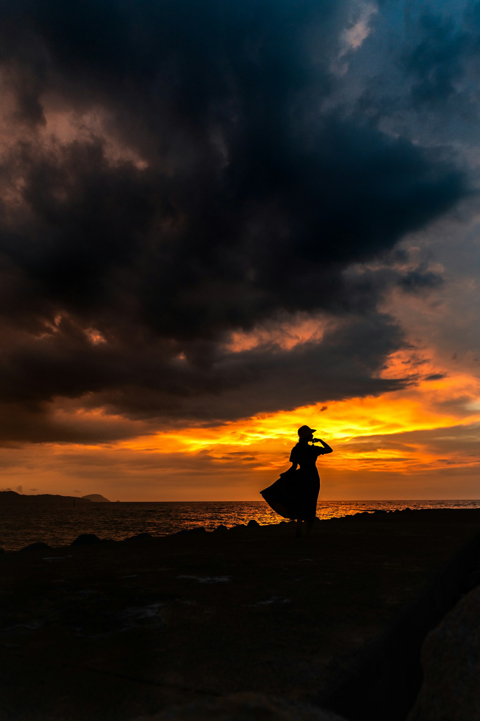 夕陽下與黑雲相伴的女性舞者剪影