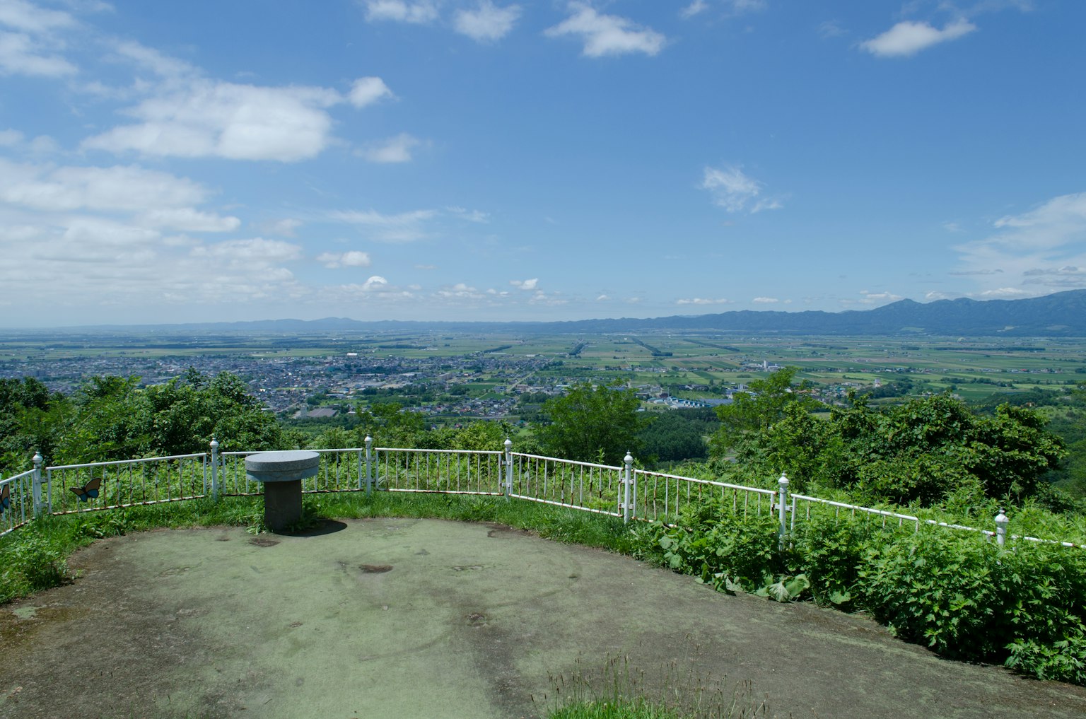 Tempat pandang yang indah menghadap pemandangan hijau subur dan gunung jauh