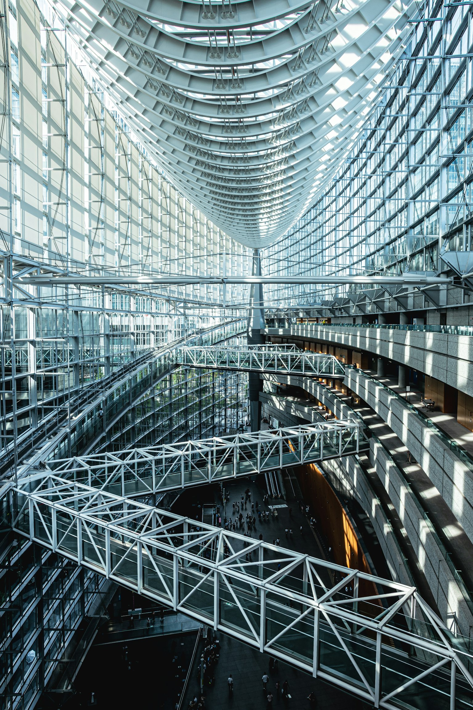Vista interna di un edificio moderno con struttura in vetro e metallo con scale a chiocciola e layout spazioso