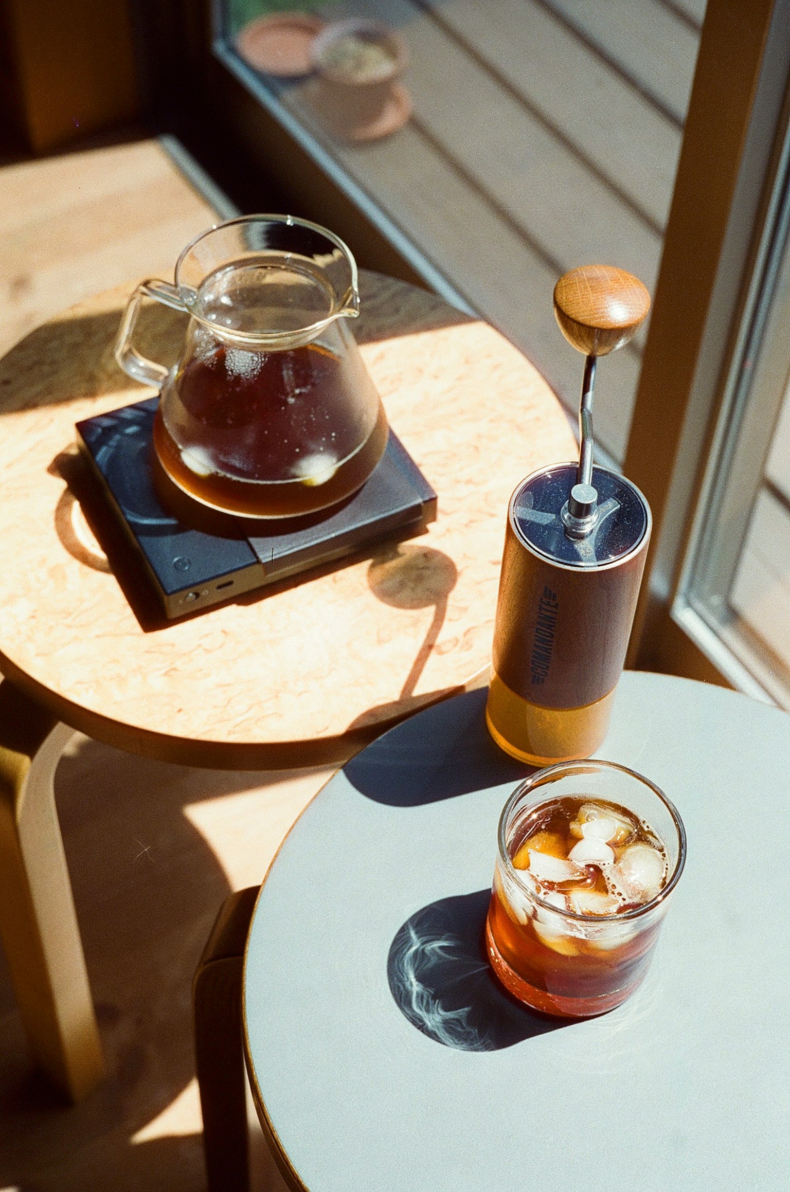 Ein Glas Eiskaffee und eine Kaffeekanne auf einem Tisch in einem Café