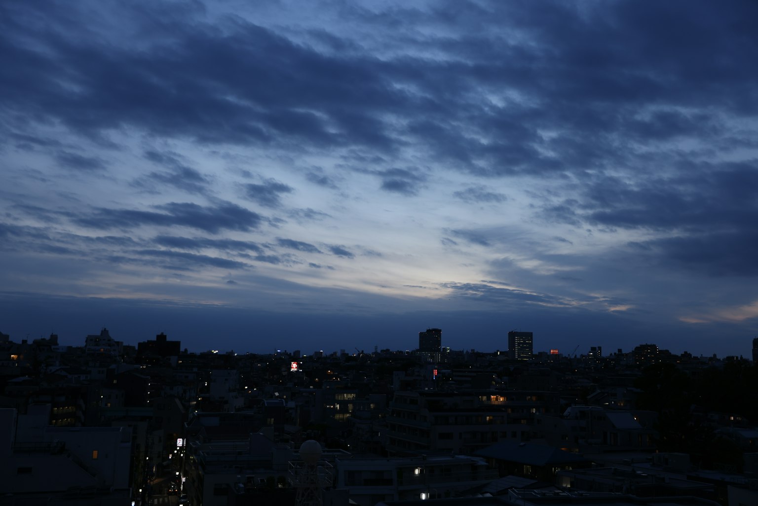 Paysage urbain nocturne avec un ciel bleu et des motifs nuageux