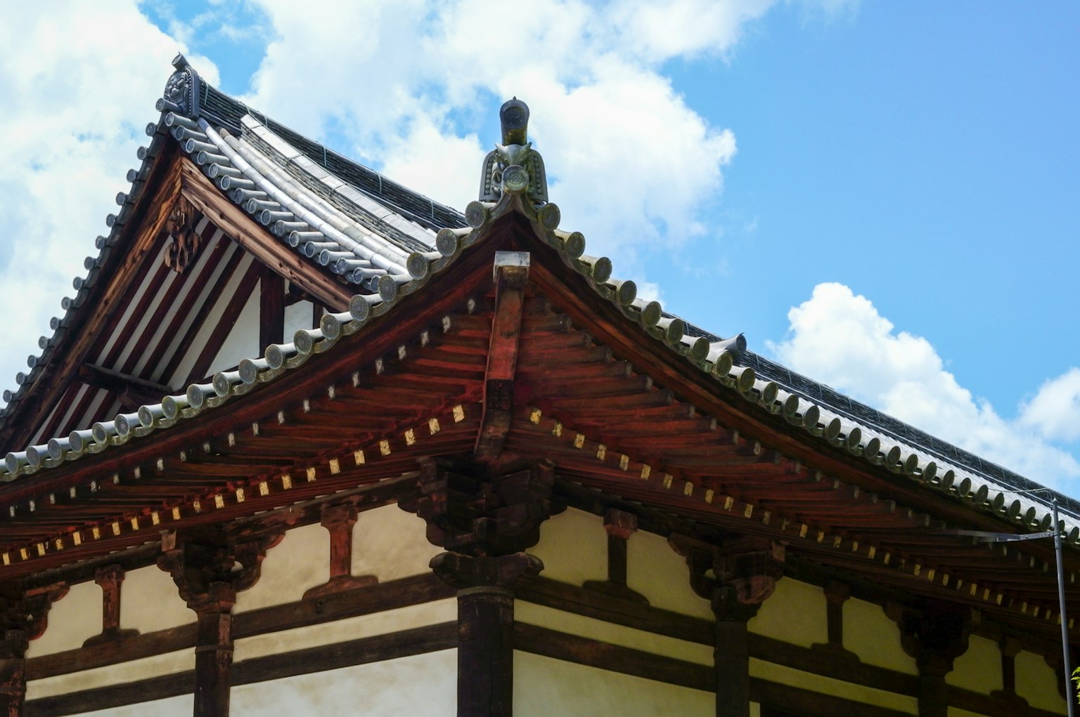 傳統日本建築屋頂，木製裝飾，藍天和白雲