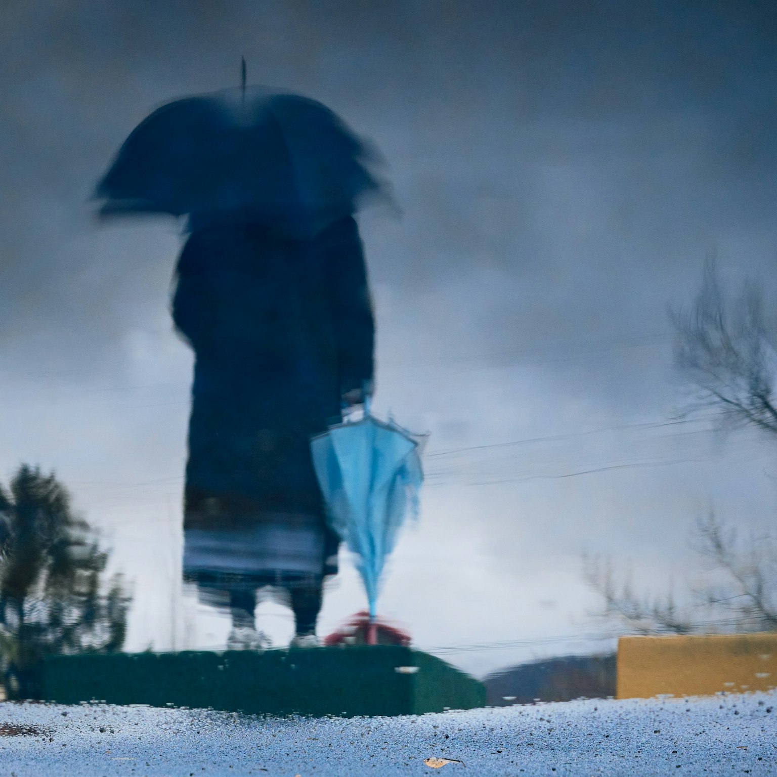 Silueta de una persona sosteniendo un paraguas en la lluvia