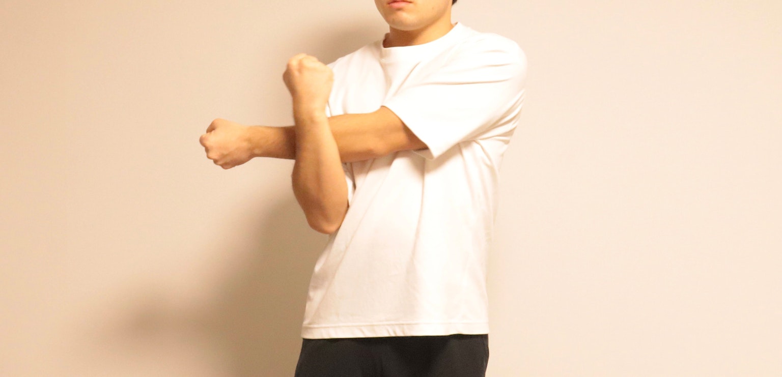 穿着白色T恤的男士正在伸展手臂