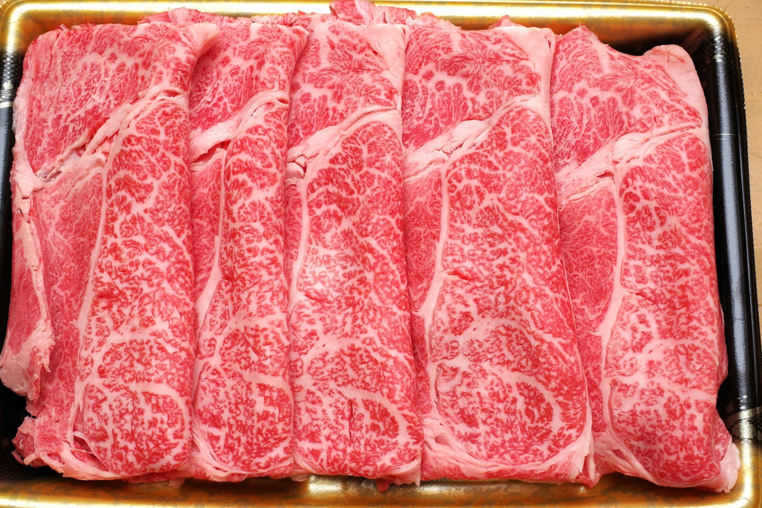 Rebanadas de carne de res maravillosamente veteadas dispuestas ordenadamente