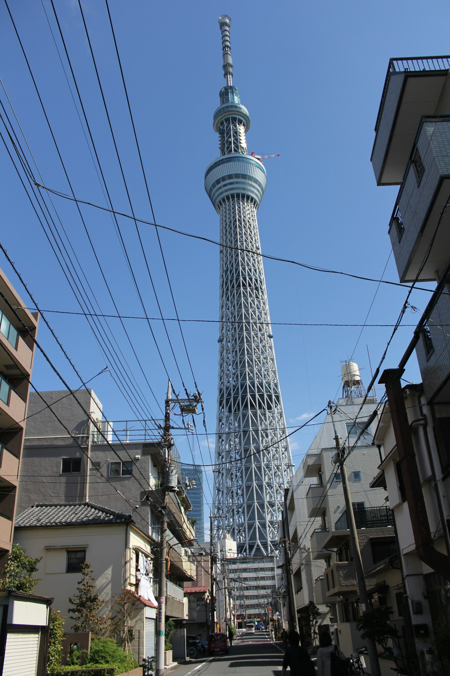 Tokyo Skytree che svetta su un paesaggio urbano sotto un cielo blu chiaro