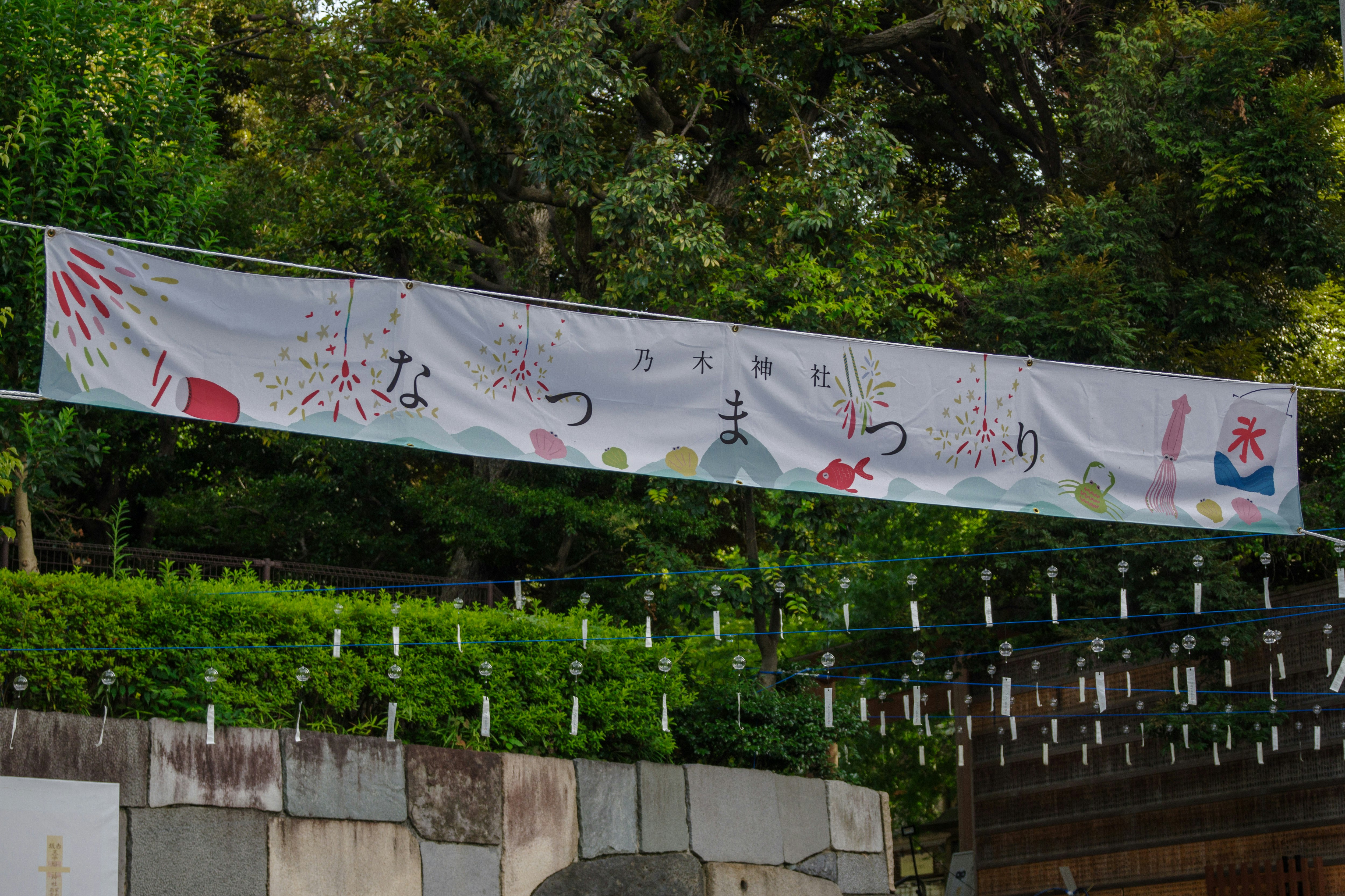 乃木神社のなつまつりの飾り旗が並ぶ参道の風景