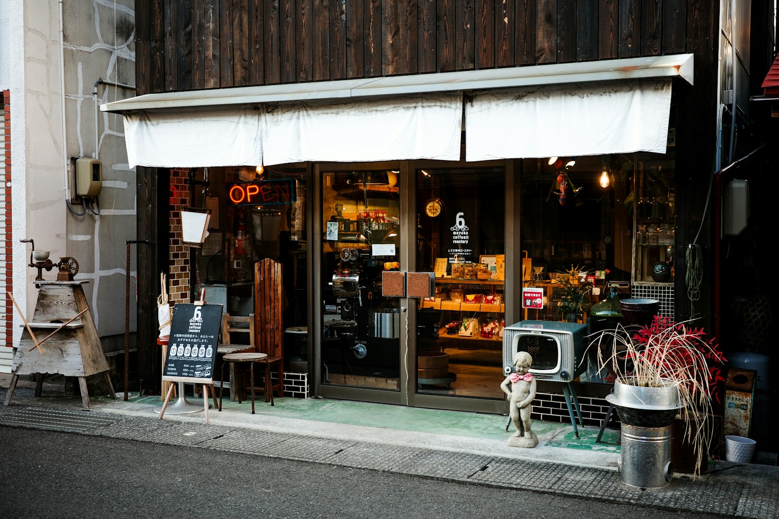 Small wooden storefront with an open sign and various displays