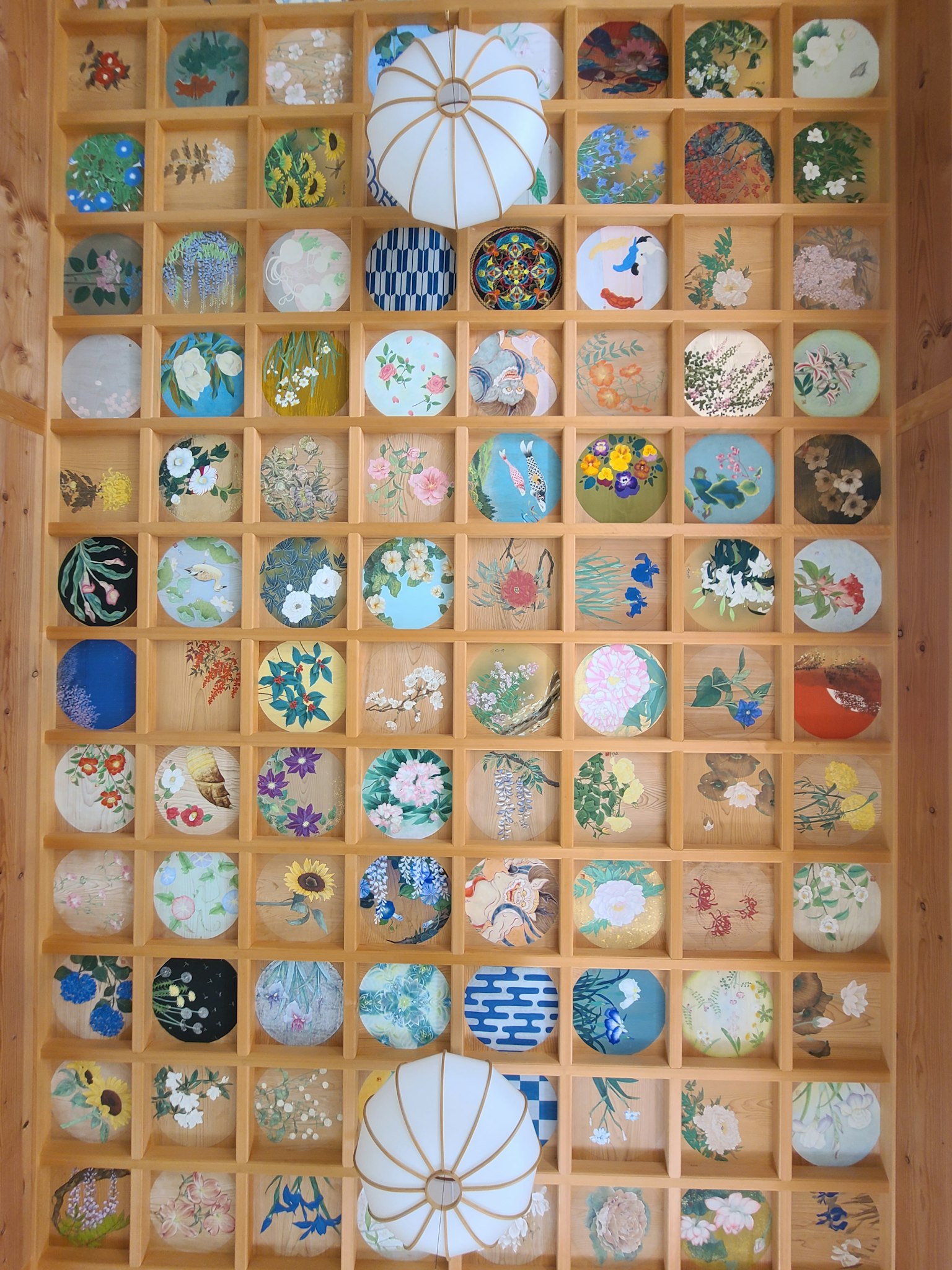 一个展示多彩图案陶瓷盘的木架，整齐排列